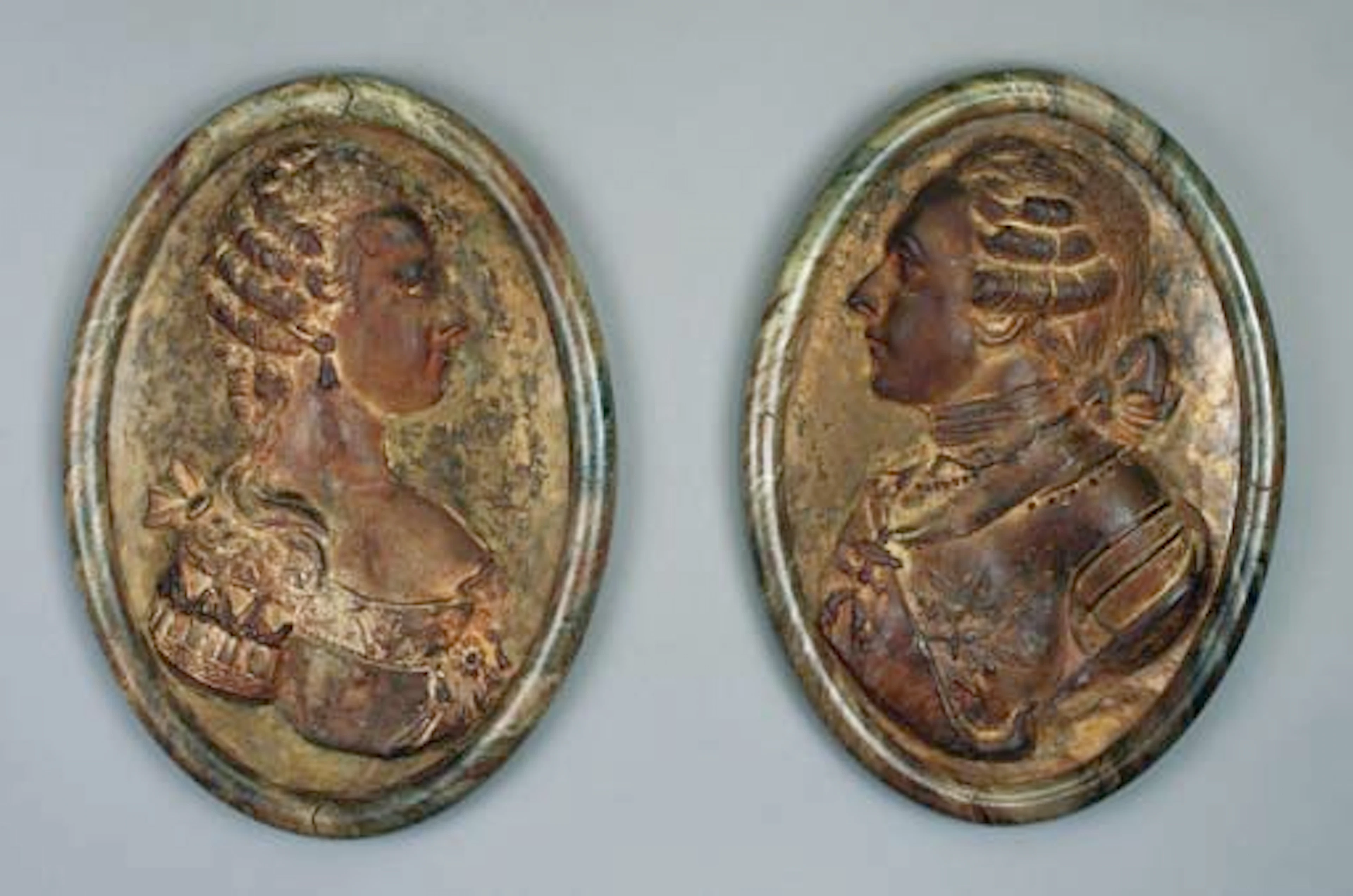 A PAIR OF LOUIS XVI MARBELIZED PLASTER OF PARIS PORTRAIT OVALS