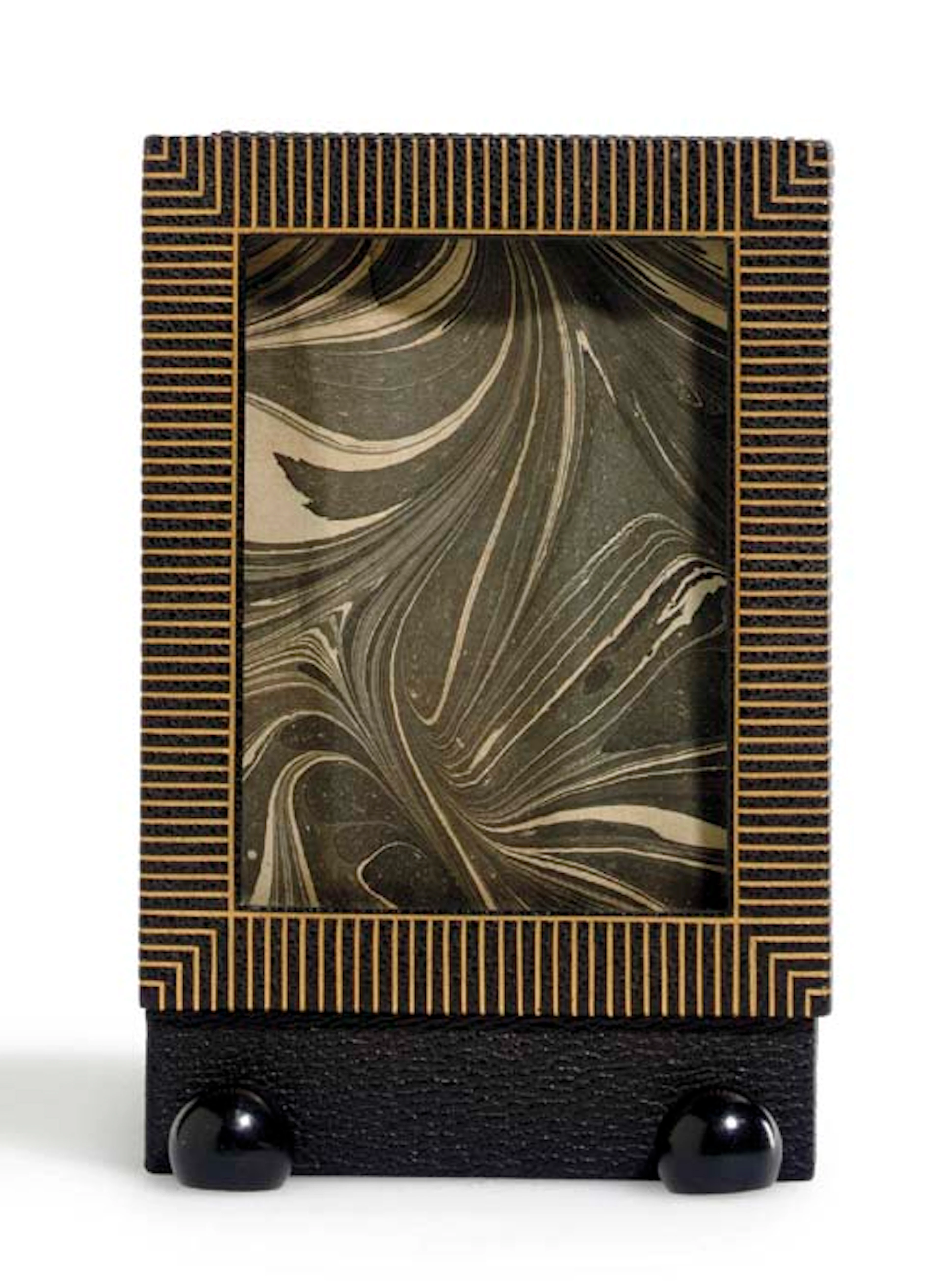 A GOLD TOOLED LEATHER FRAME WITH EBONIZED WOOD FEET, CIRCA 1908