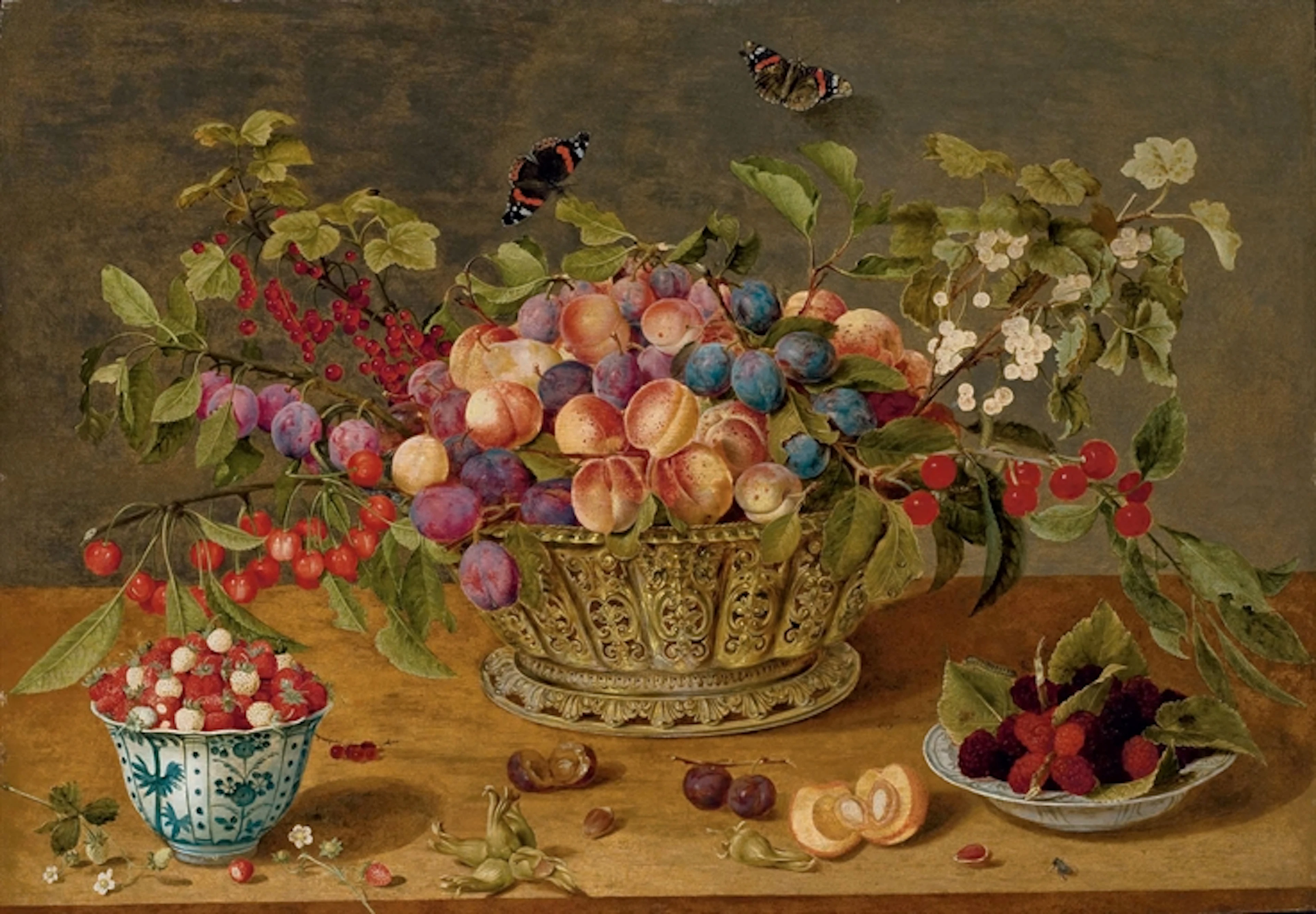 Prunes, abricots, cerises et groseilles dans une corbeille avec coupelles de framboises et de fraises des bois sur un entablement