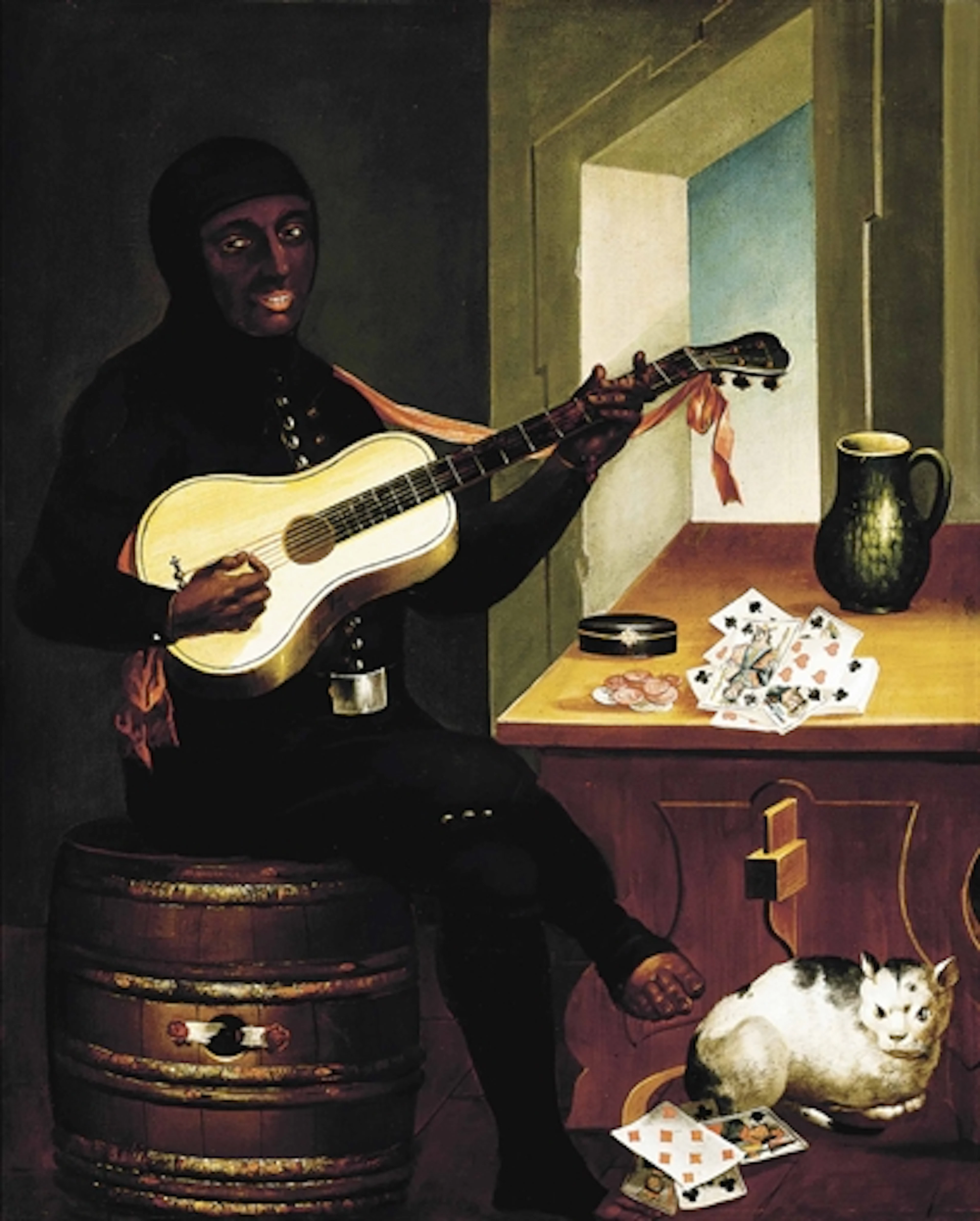 A man playing a guitar in an interior, with cards and coins on a table and a cat sitting by his foot