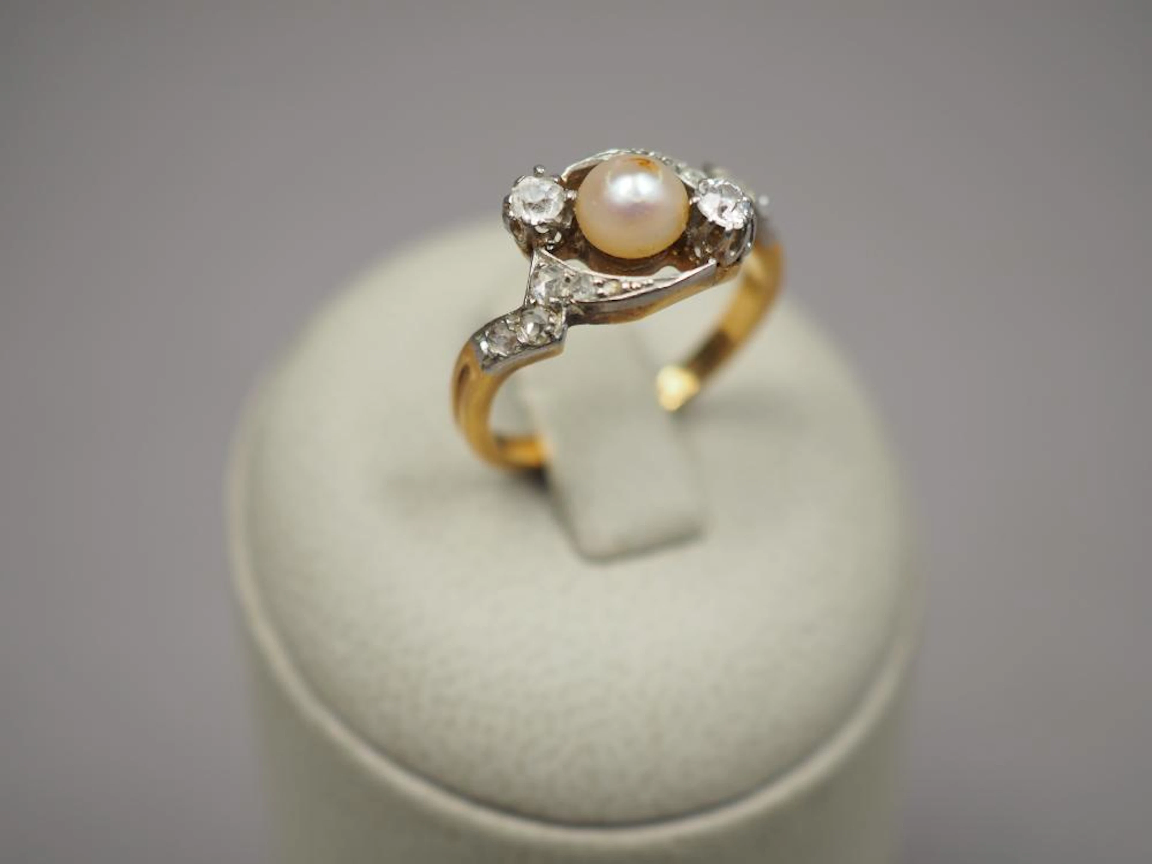 Bague en or jaune, ornée d'une perle entourée de diamant et de roses. TDD.