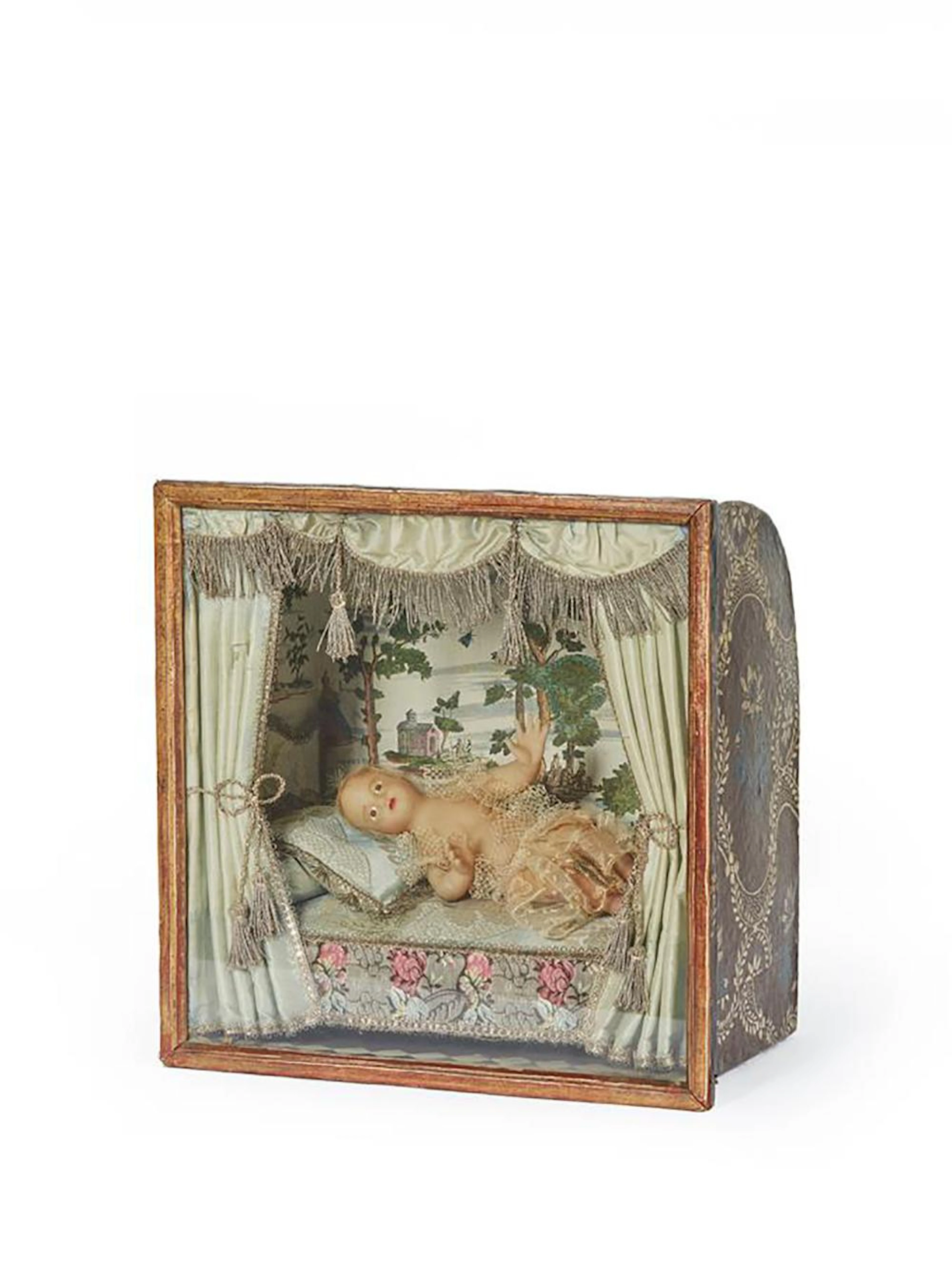 Boite vitrine représentant l'Enfant-Jésus en cire habillé de dentelle.