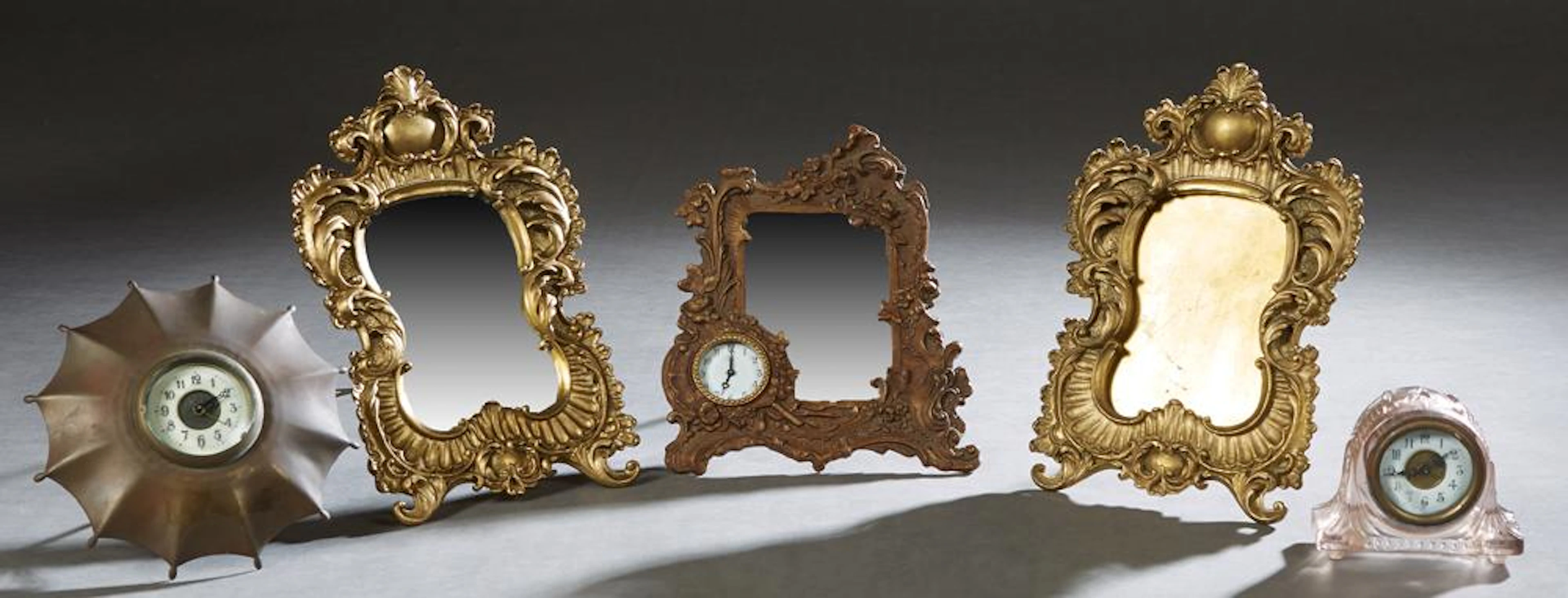Five Pieces of Bric-a-Brac, 20th c., consisting of a bronze umbrella with a central clock; a pink molded glass desk clock; a bronze...