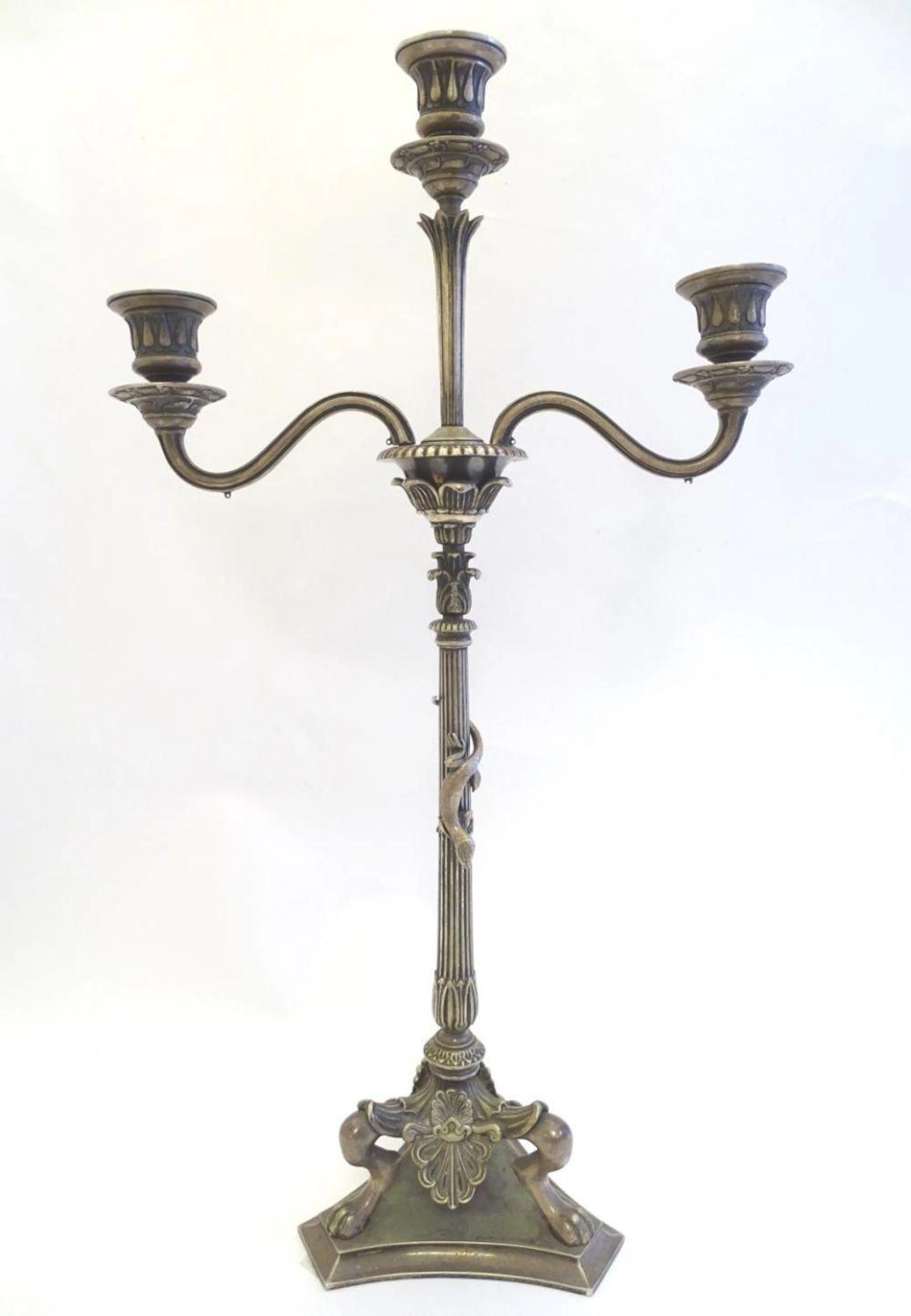 A Victorian silver plate three branch candelabra, with engraved armorial to base, lion's paw feet, w