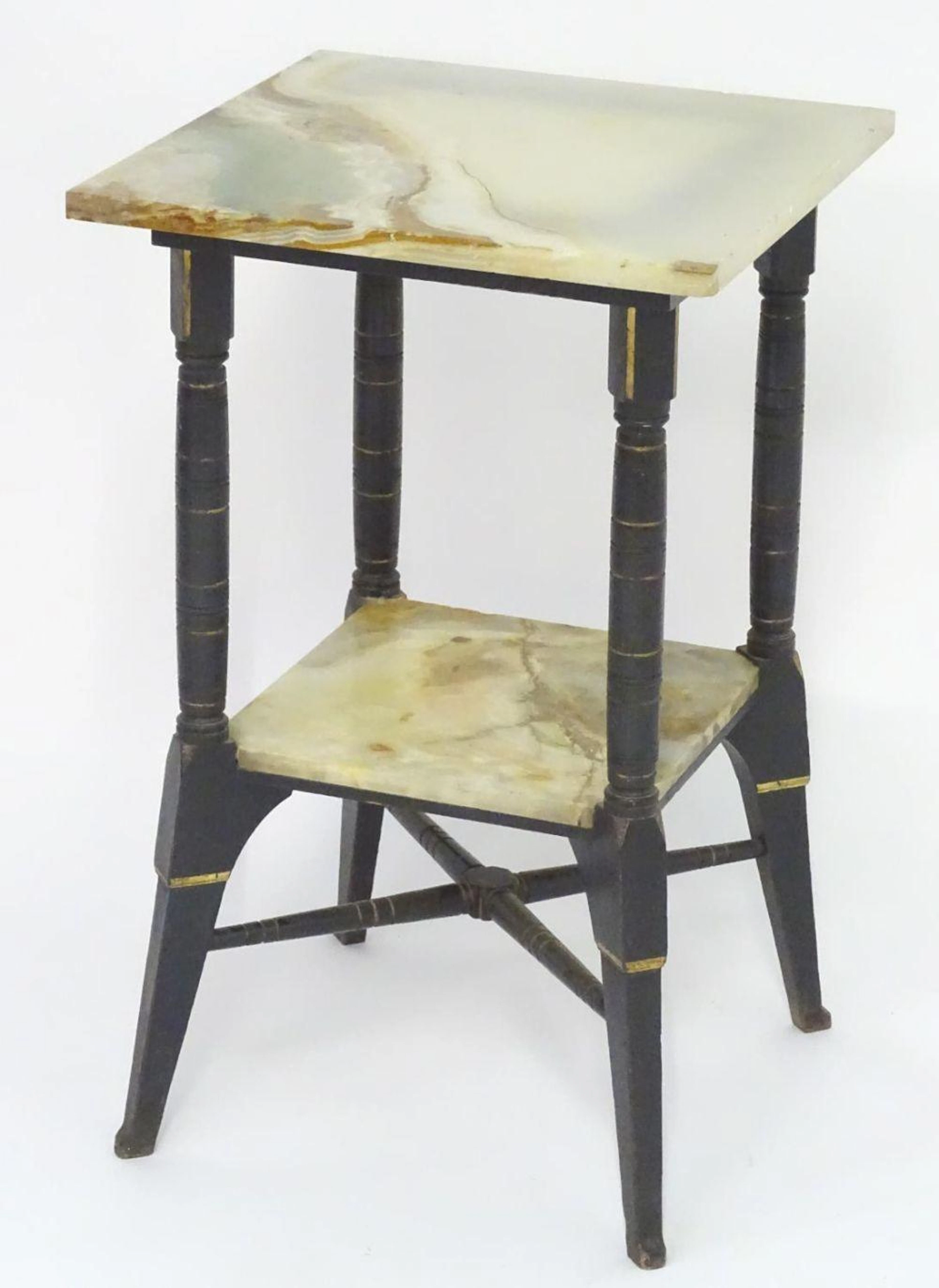 An Aesthetic movement table with two onyx tiers and an ebonised frame with gilt highlights, the spla