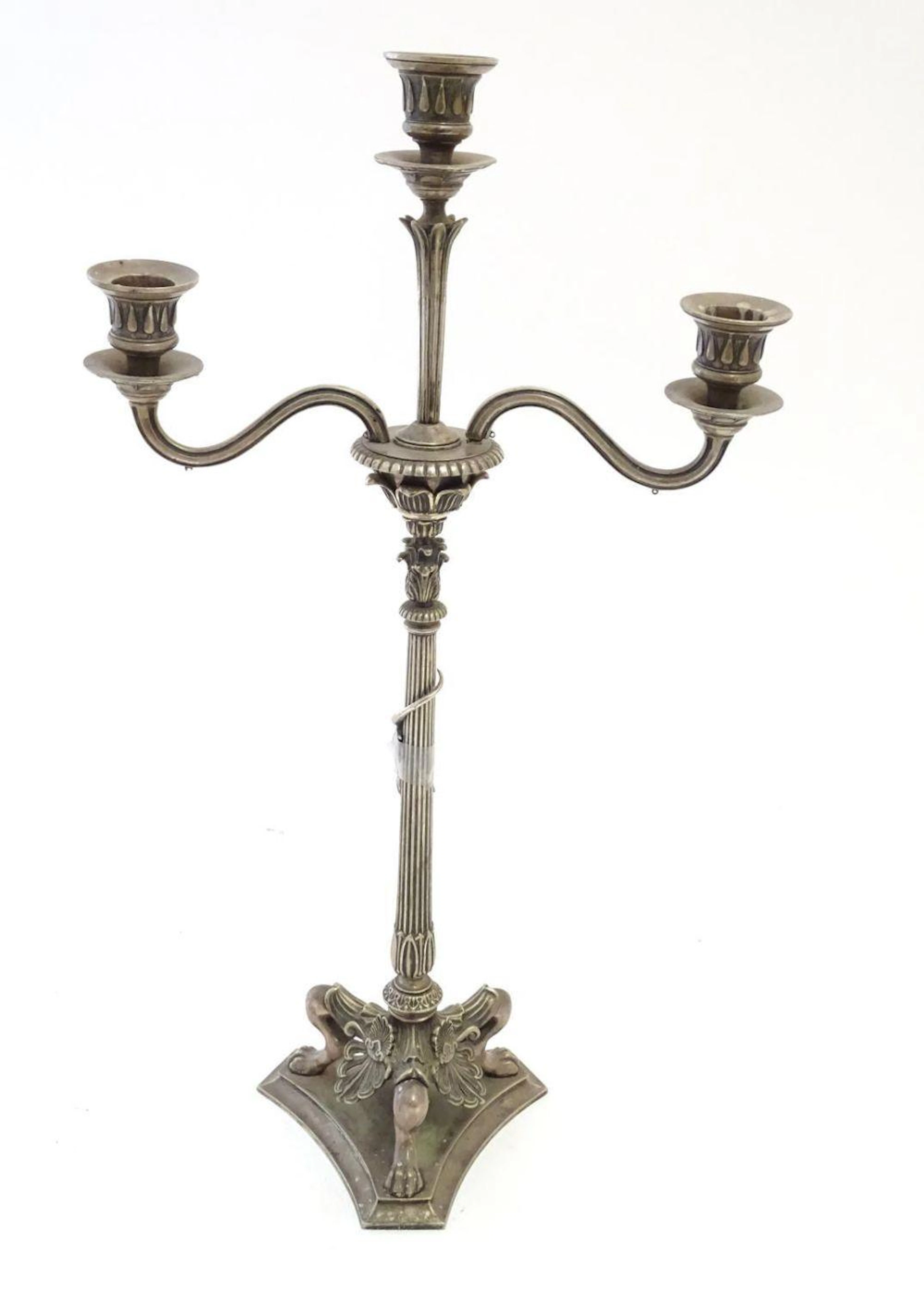 A Victorian silver plate three branch candelabra, with engraved armorial to base, lion's paw feet, w