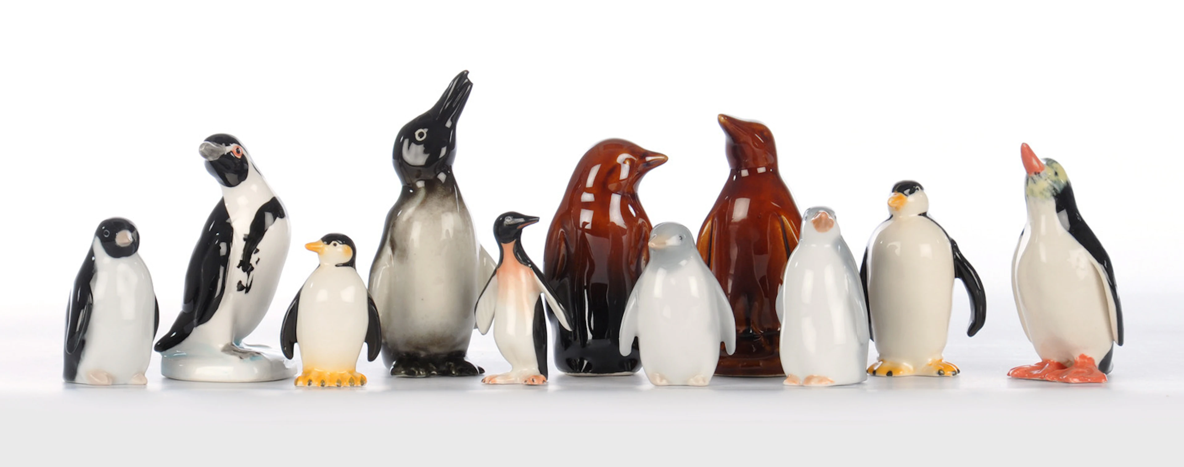 11 PINGUINE. Kleine farbige Porzellanfiguren.