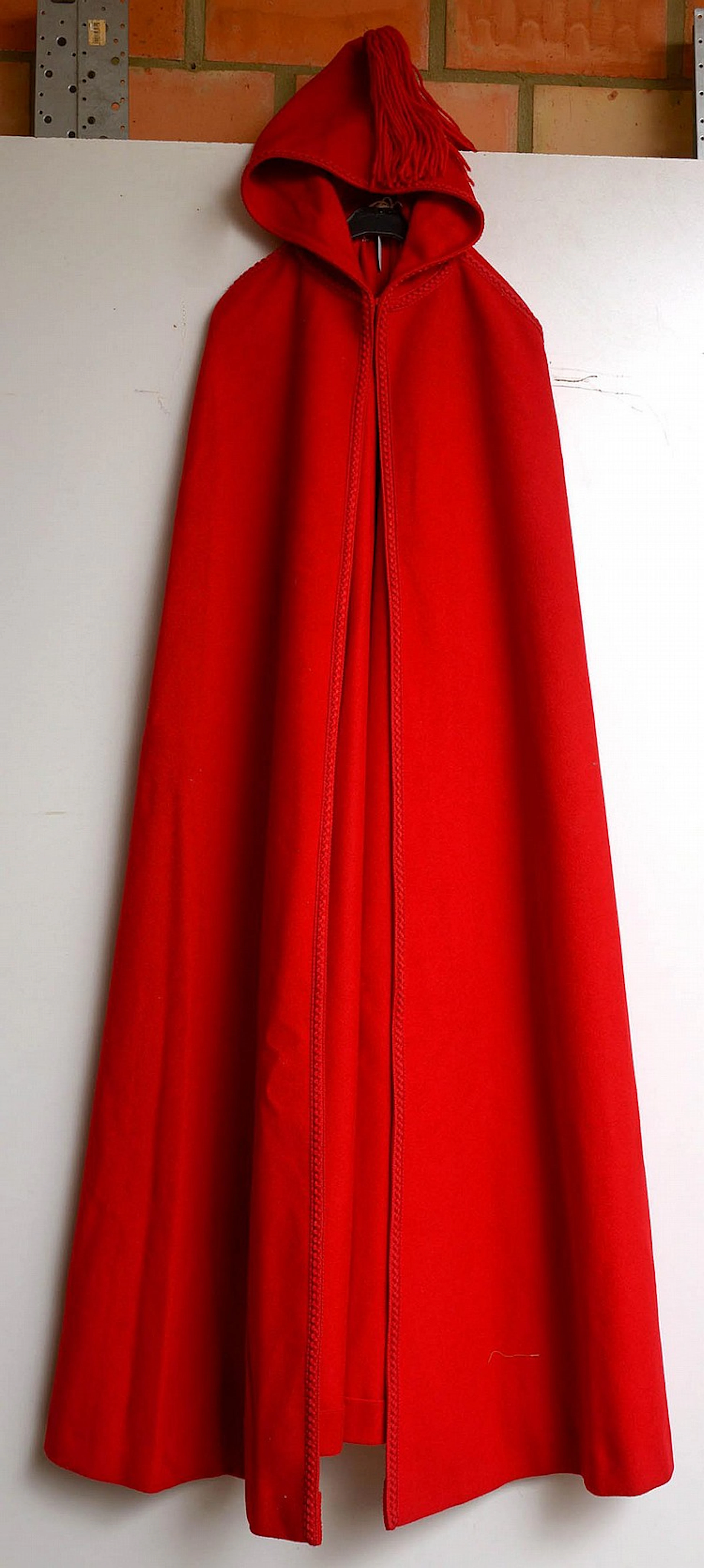 Cape avec capuche décorée d'un pompon