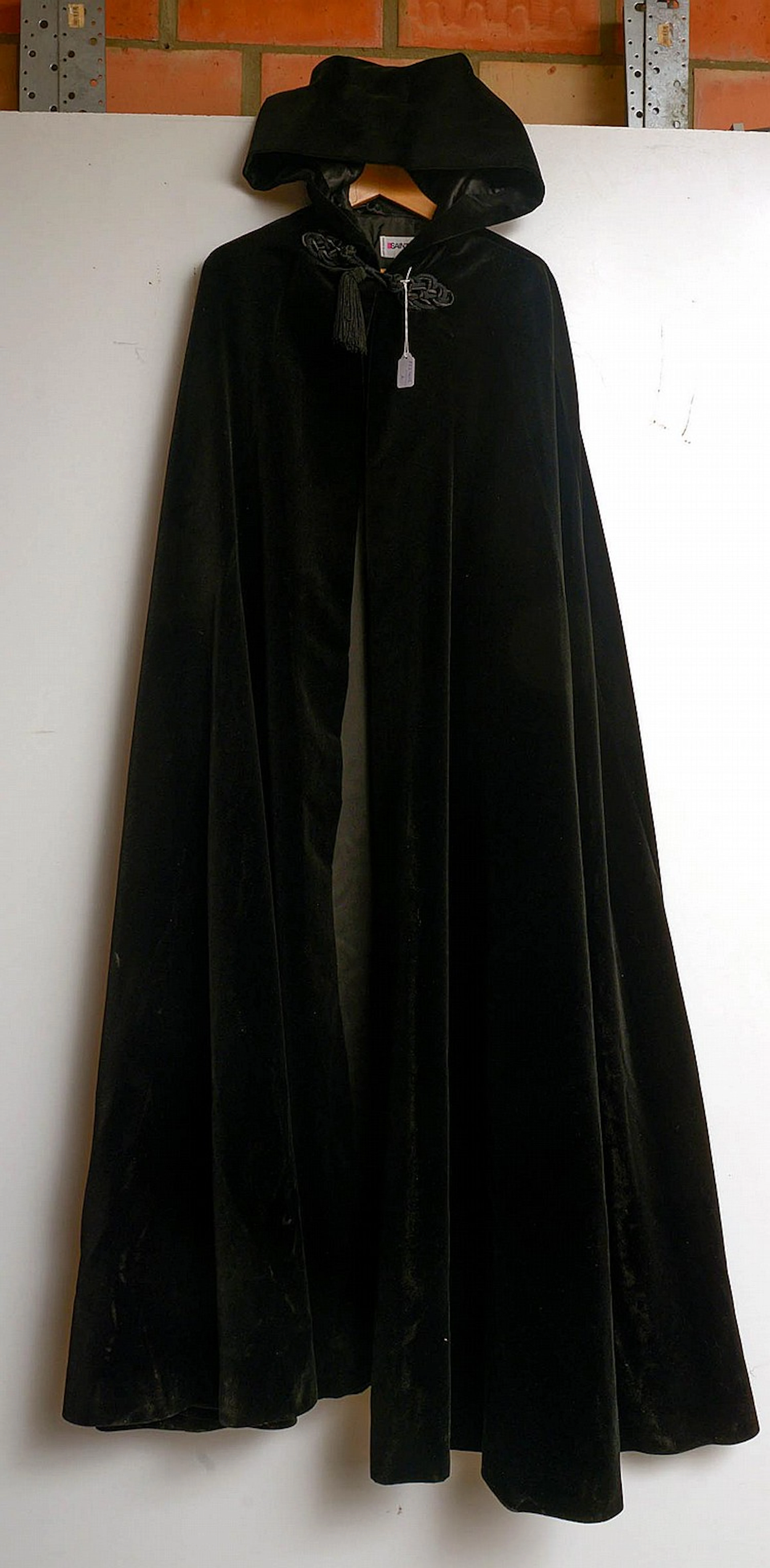 Cape avec capuche décorée d'un pompon