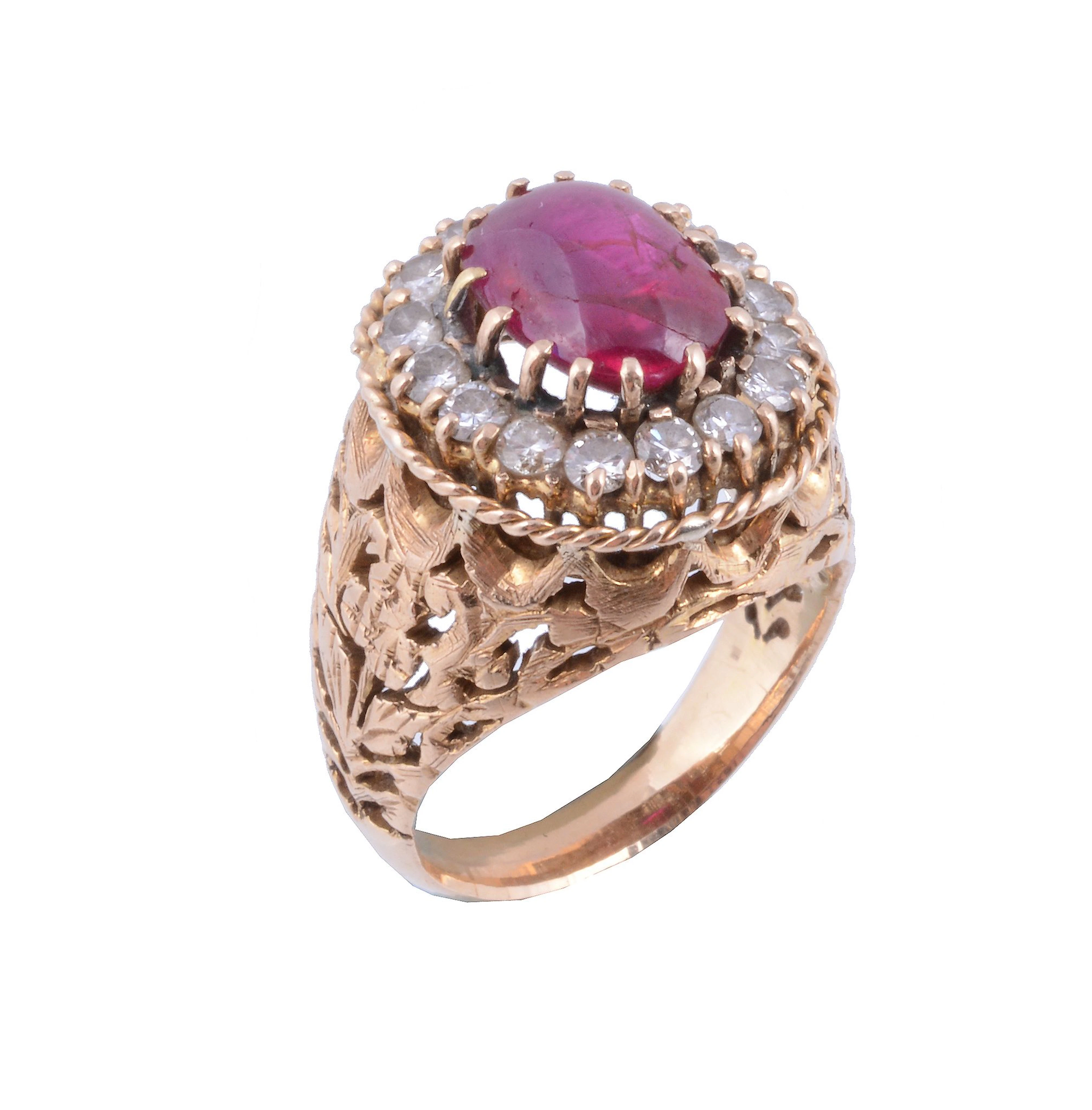 A ruby and diamond cluster dress ring, the oval cabochon ruby within a...