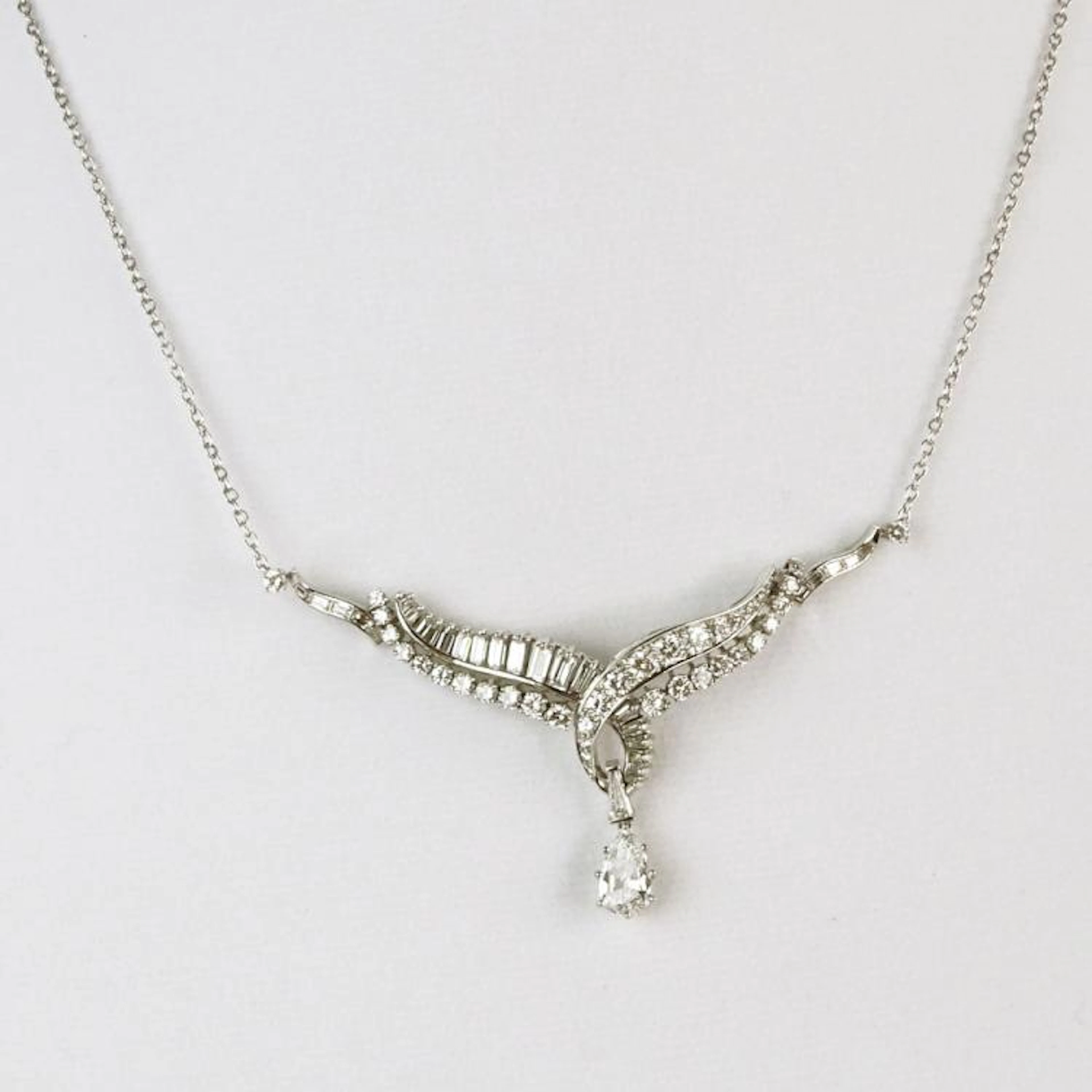 Vintage Diamond and Platinum Necklace with Center Approx. 1.01 Carat Pear Shape Diamond and accented with 5.50 Carat Round Brilliant and Baguette Cut Diamonds. Diamonds E-F color, VS1-VS2 clarity. Cla