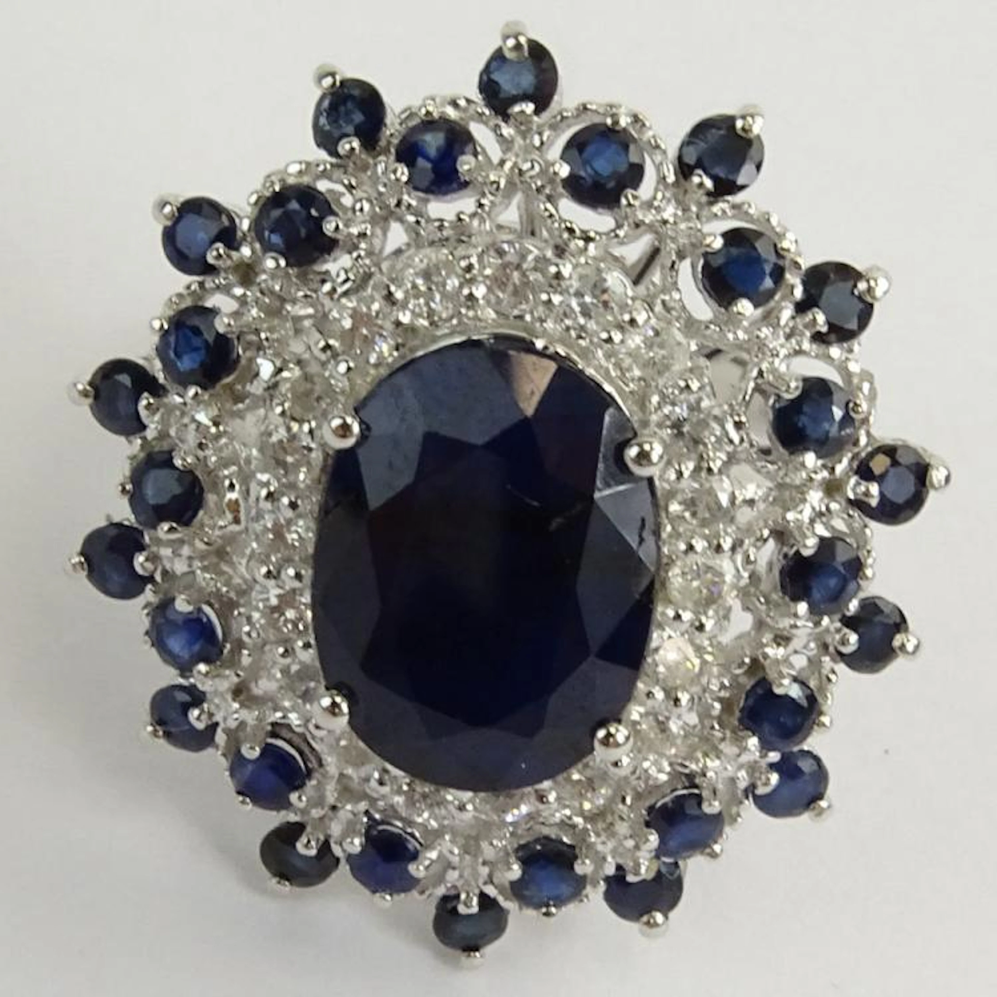 GGA Certified 9.07 Carat Oval and Round Cut Sapphire and 14 Karat White Gold Ring Accented with 1.09 Carat Round Brilliant Cut Diamonds. Diamonds H-I color, I1-I2 clarity. Signed 14K. Ring size 6-1/2.