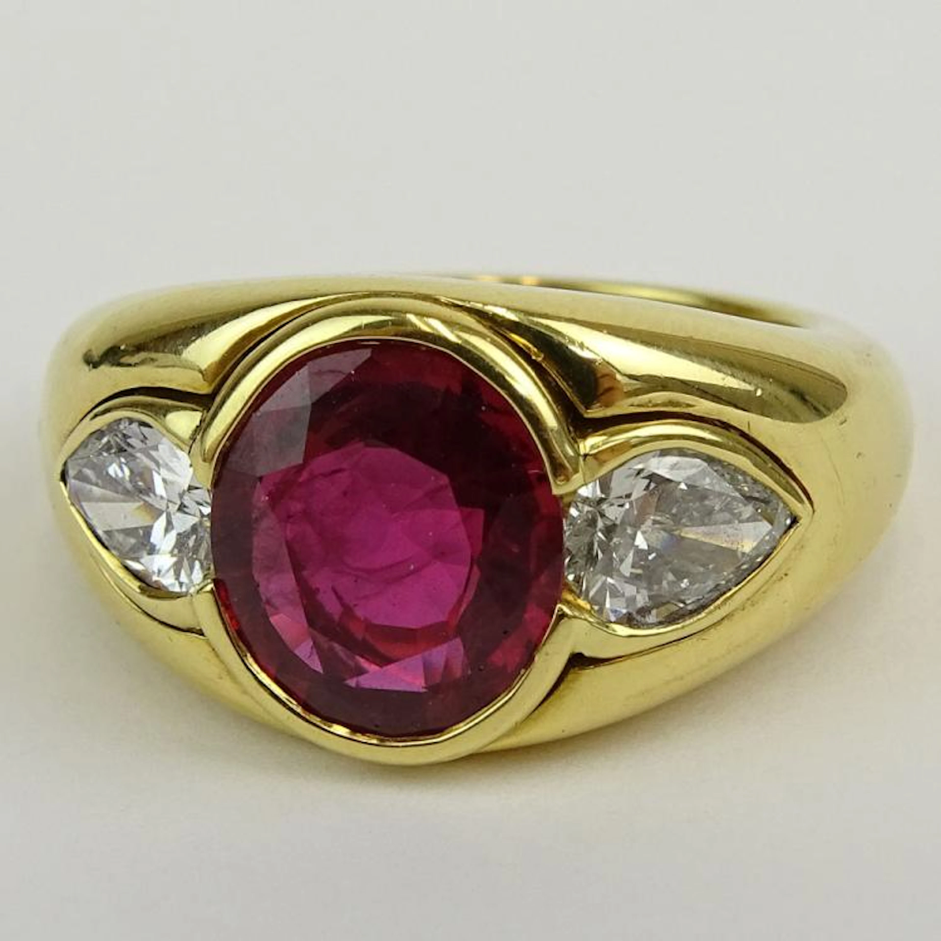 Important Vintage Bulgari 5.0 Carat Oval Cut Natural Ruby and 18 Karat Yellow Gold Ring accented with two 92) Pear Shape Diamonds 1.10 Carat TW. Ruby with vivid saturation of color. Diamonds E-F color
