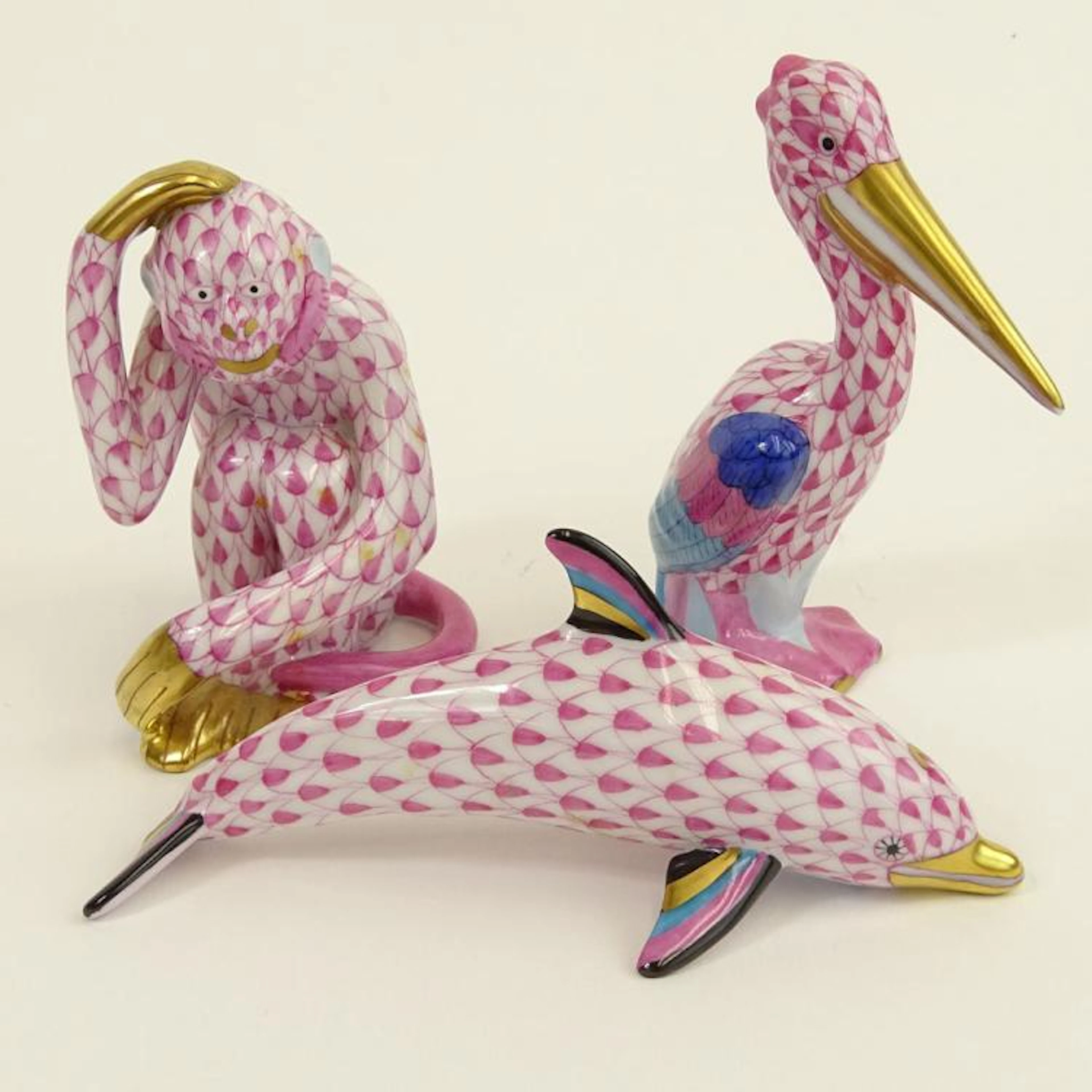 Lot of Three (3) Herend Porcelain Animal Figurines. Includes pelican, pink fishnet 3-1/2"; monkey, pink fishnet; dolphin, pink fishnet. All pieces are signed appropriately. Tiny chip on beak or good c