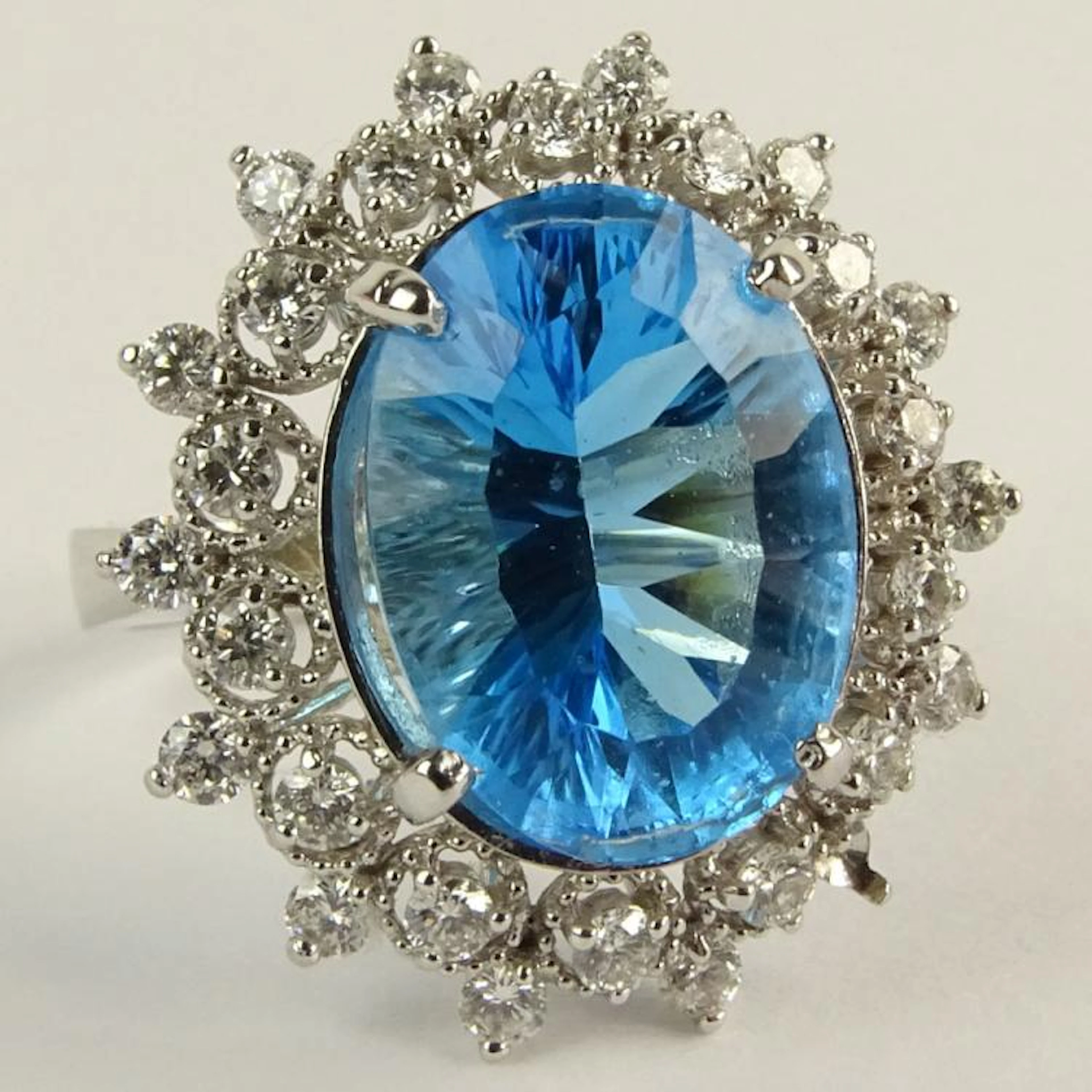 Lady's Oval Cut London Topaz, Round Brilliant Cut Diamond and 14 Karat White Gold Ring. Topaz measures 14mm x 10mm. Diamonds E-F color, SI clarity. Signed 14K. Very good condition. Ring size 7. Approx