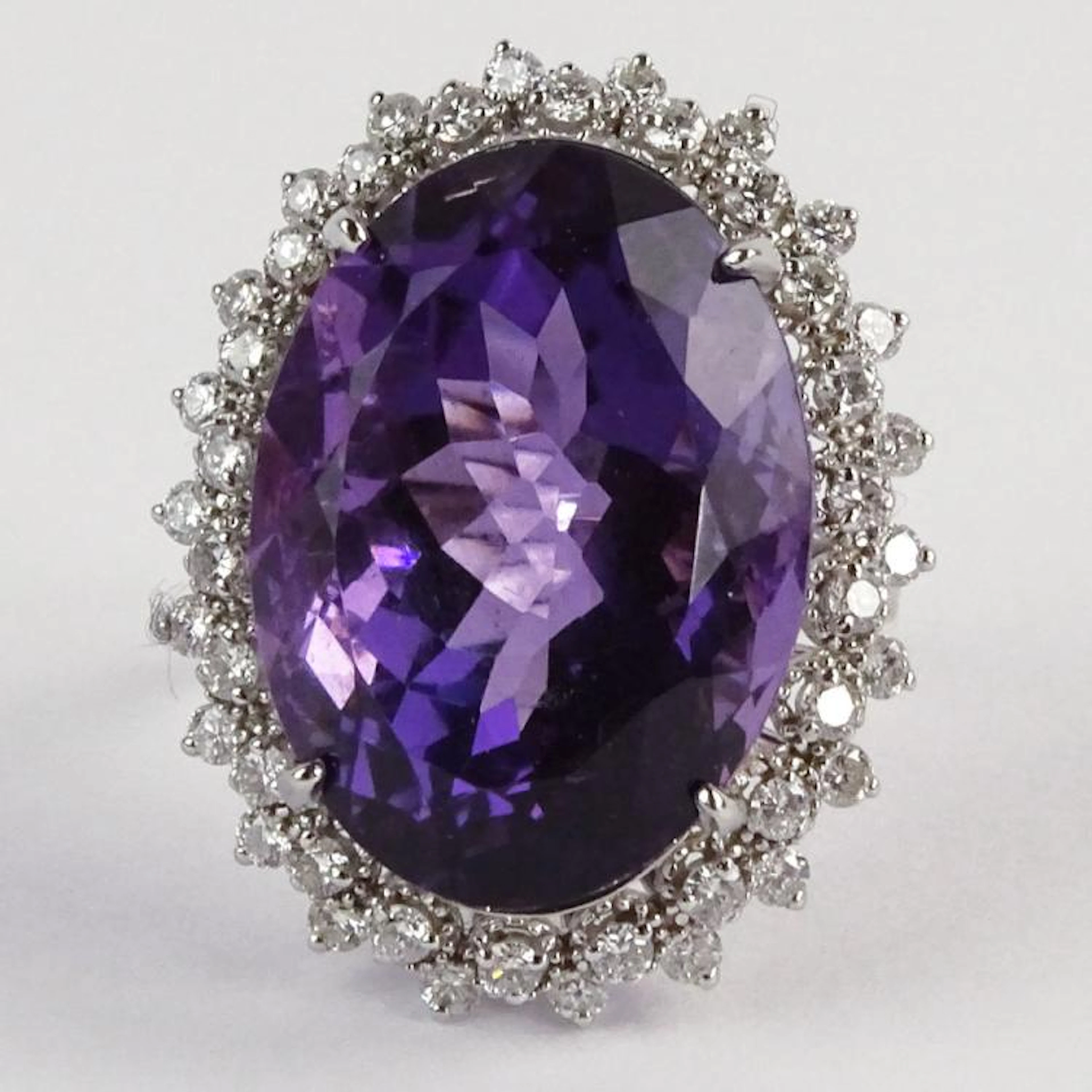 Large Oval Cut Amethyst, Diamond and 14 Karat White Gold Ring. Amethyst with vivid saturation of color measures approx. 22mm x 16mm. Diamonds E-F color, SI clarity. Signed 14K. Very good condition. Ri