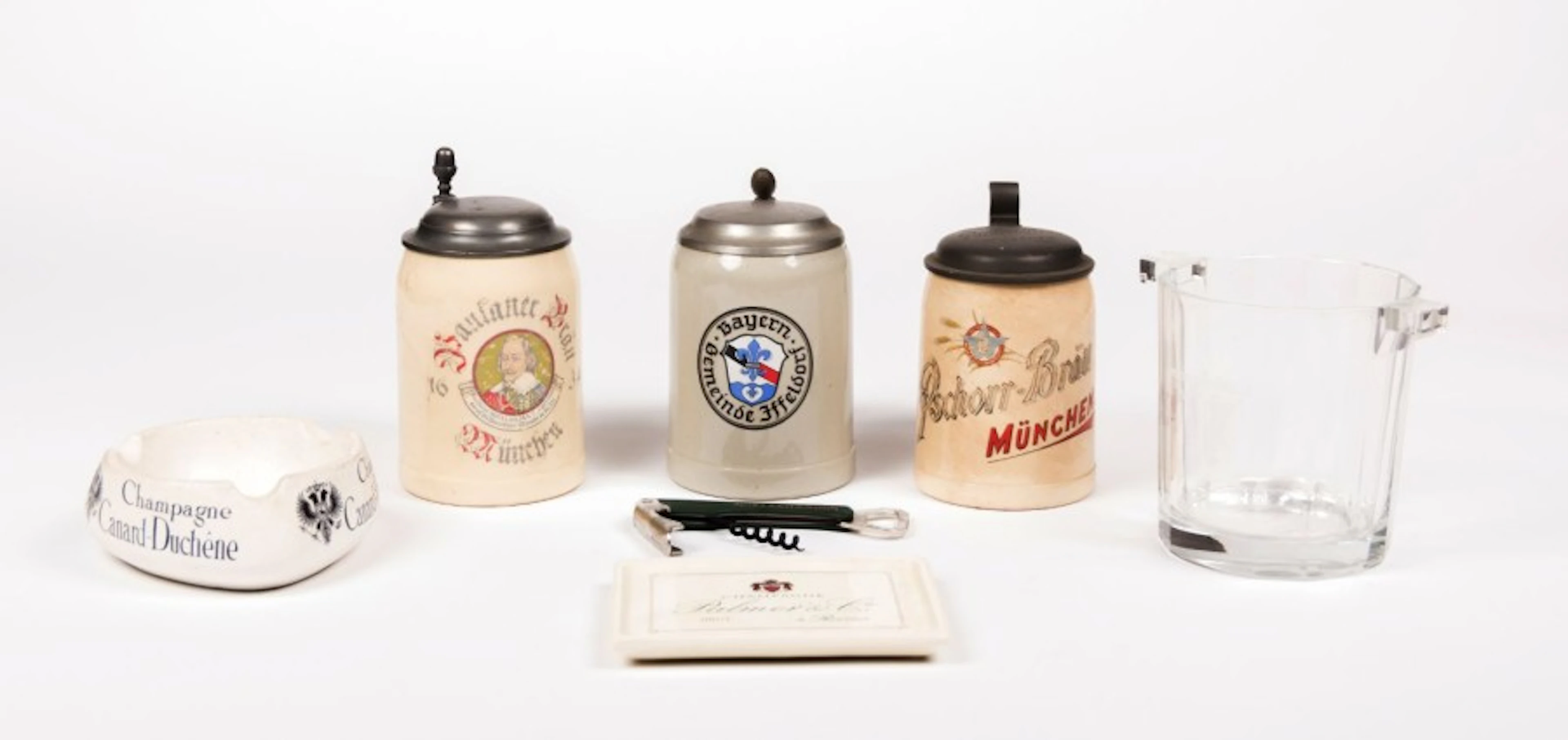 Lot comportant trois chopes à bière en faïence à couvercle à...
