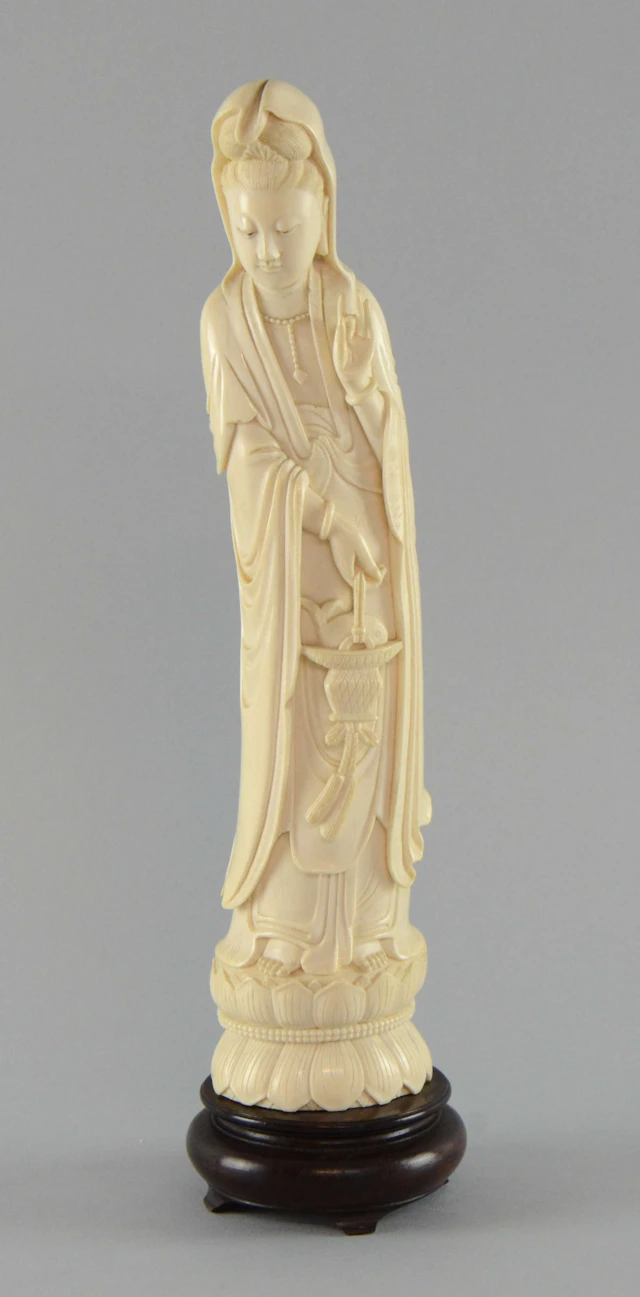 Early 20th century Chinese carved ivory figure of Guanyin in typical pose and holding a basket of fish