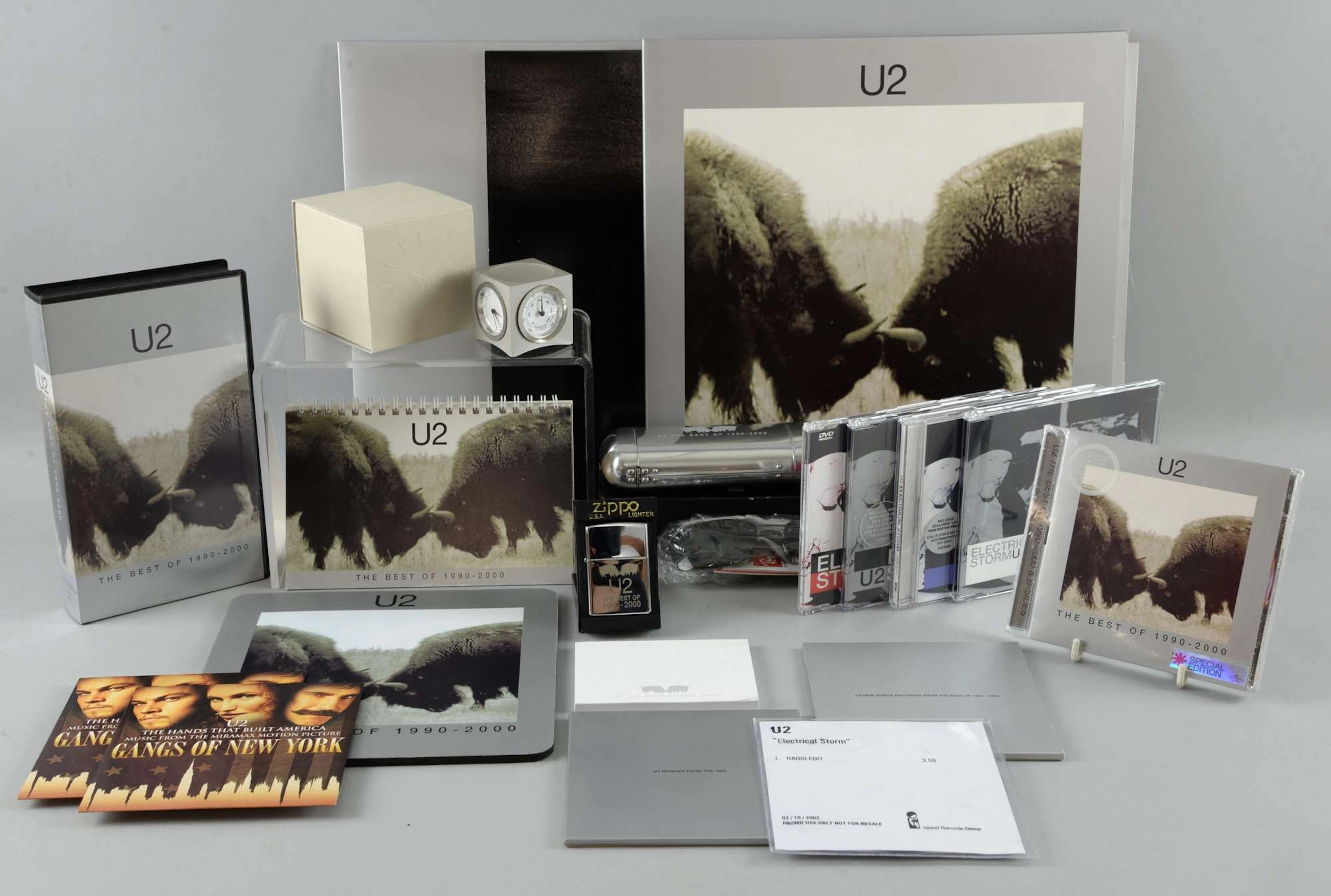 U2 The Best Of 1990 - 2000 double Vinyl, double CD, bonus DVD, Ray-Ban sunglasses in special U2 case, Cube weather & time station with U2 album logo, Zippo lighter, mousemat, calendar, post-it notes, 