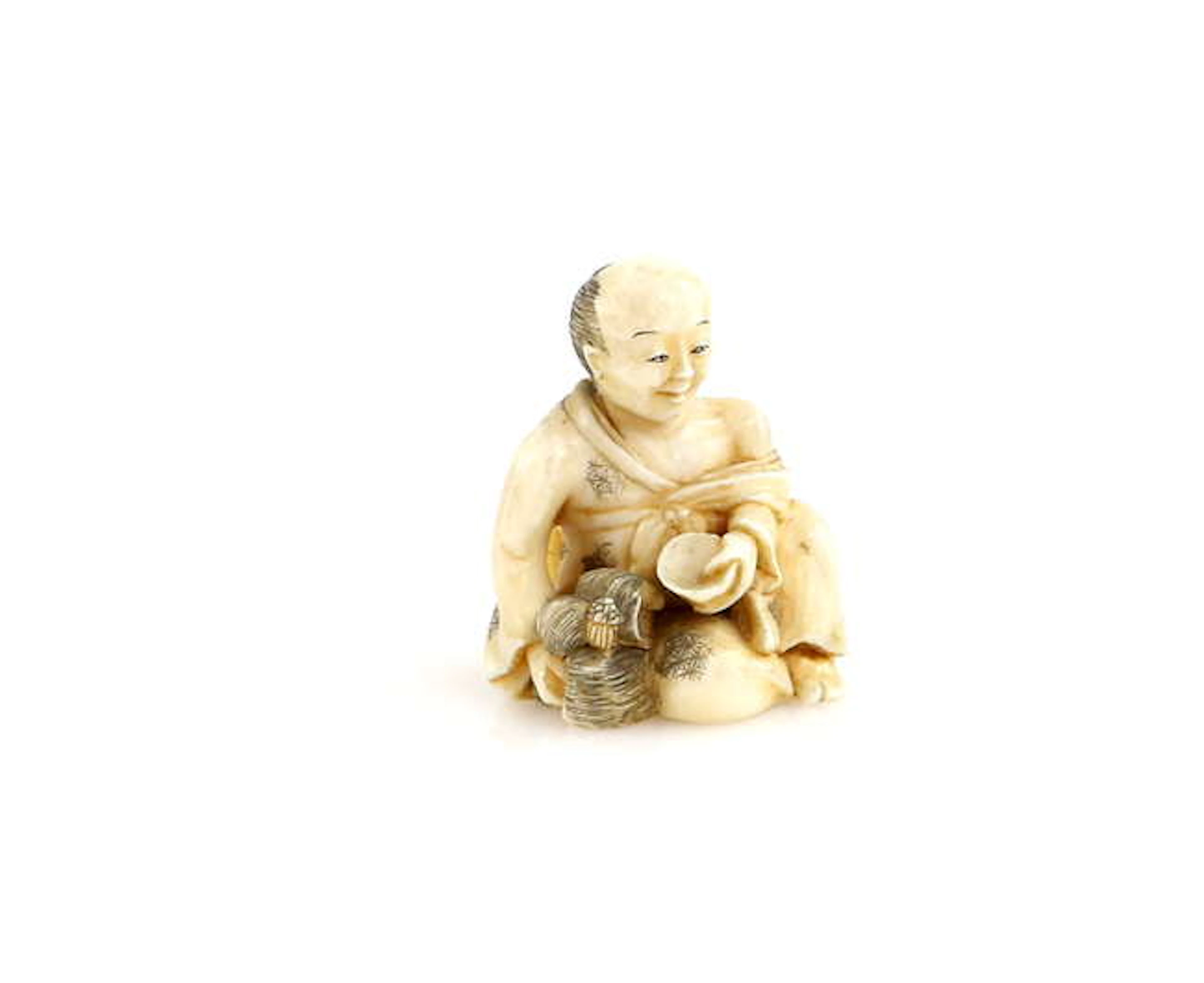 A stained ivory netsuke of a seated Onnagata holding his...