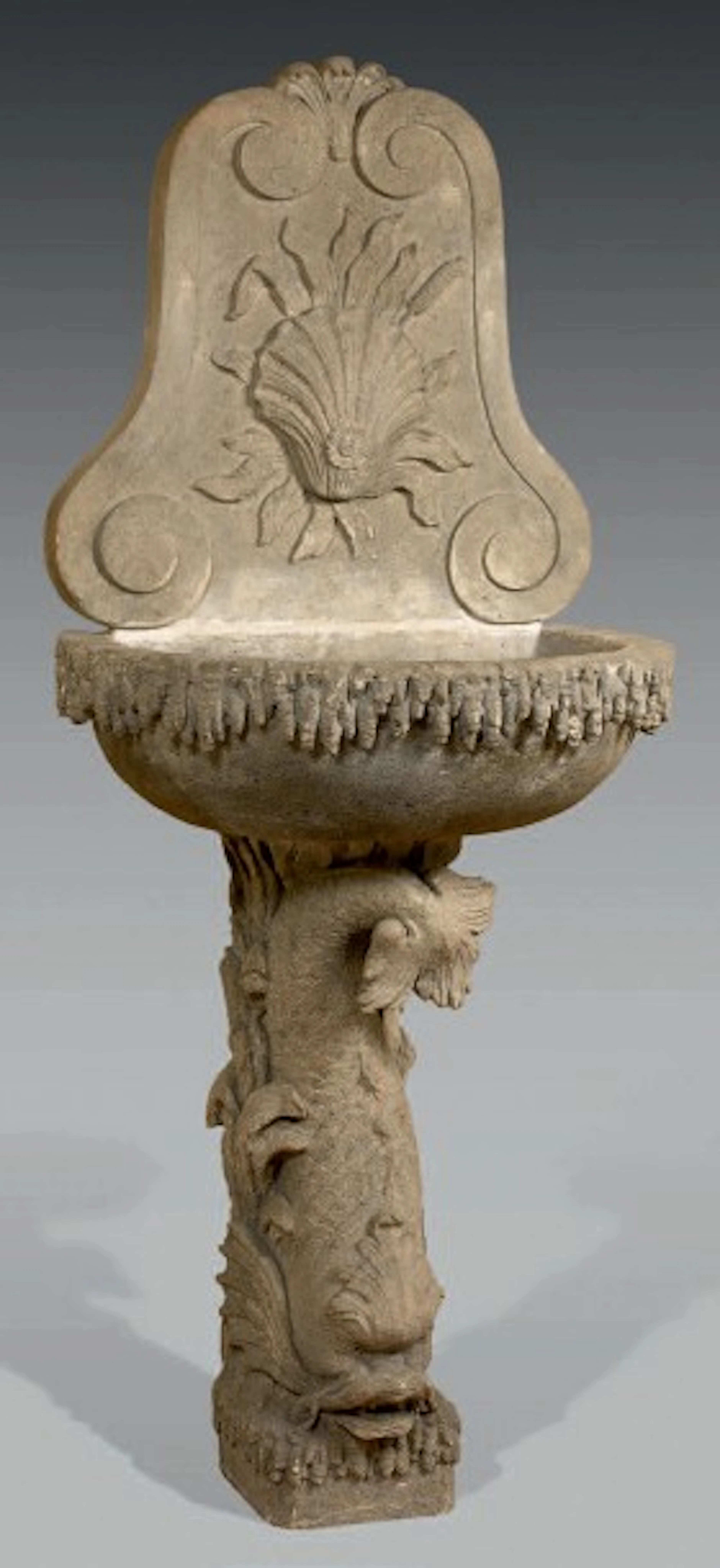 Fontaine en pierre grise sculptée à décor de coquille