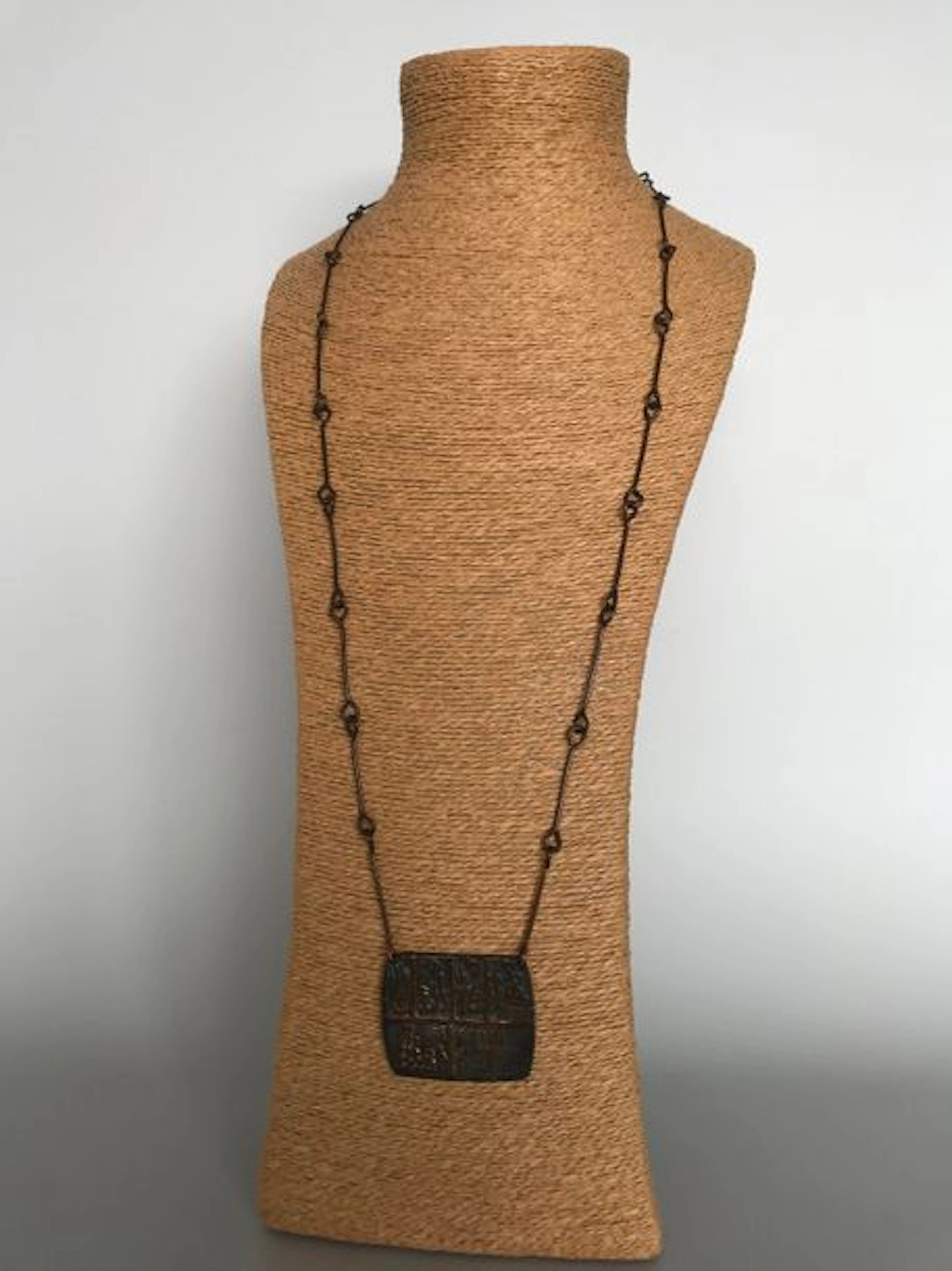 Long collier d'inspiration ethnique à plaque…