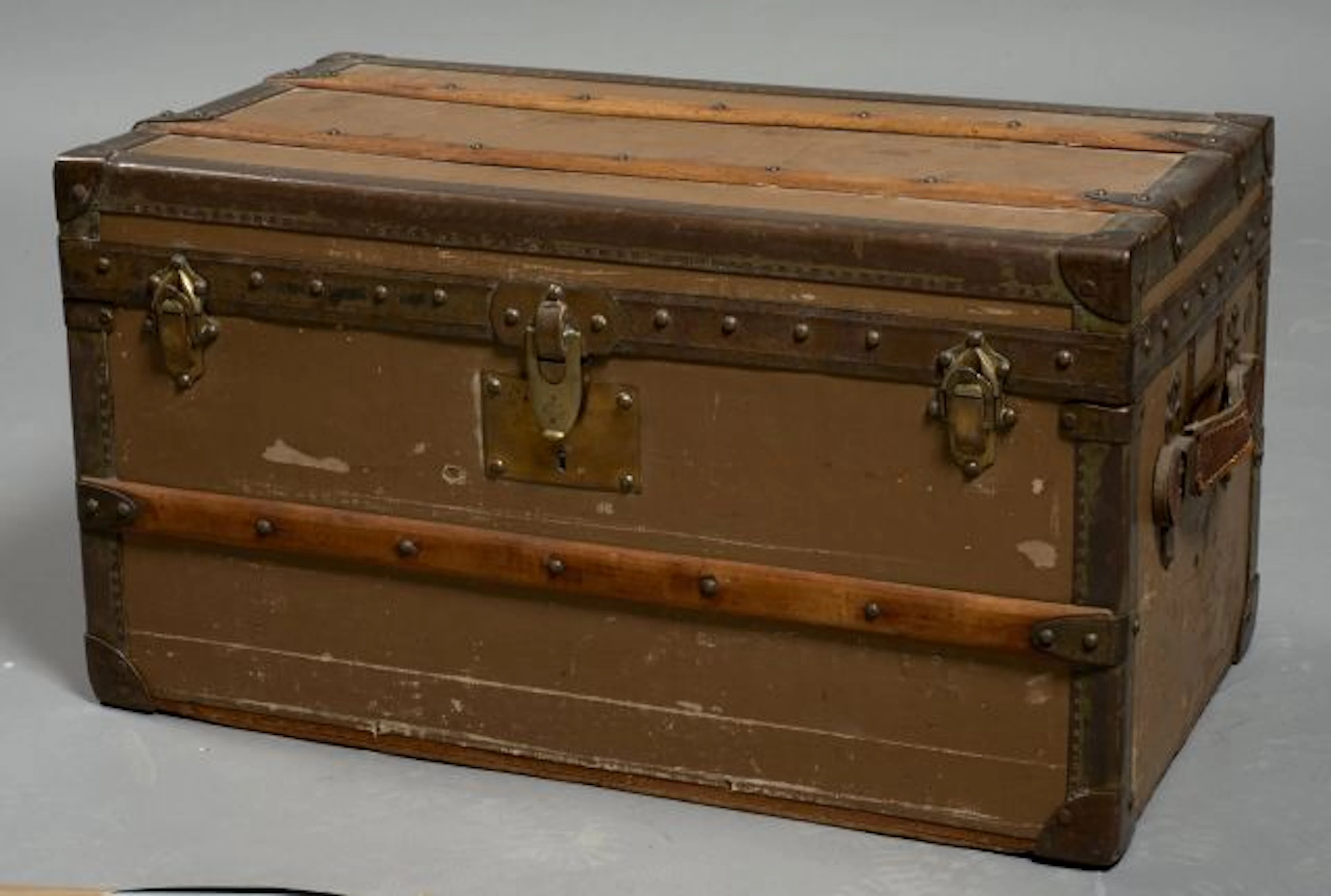 MOYNAT, Petite malle de voyage en toile marron sur bois, bordures