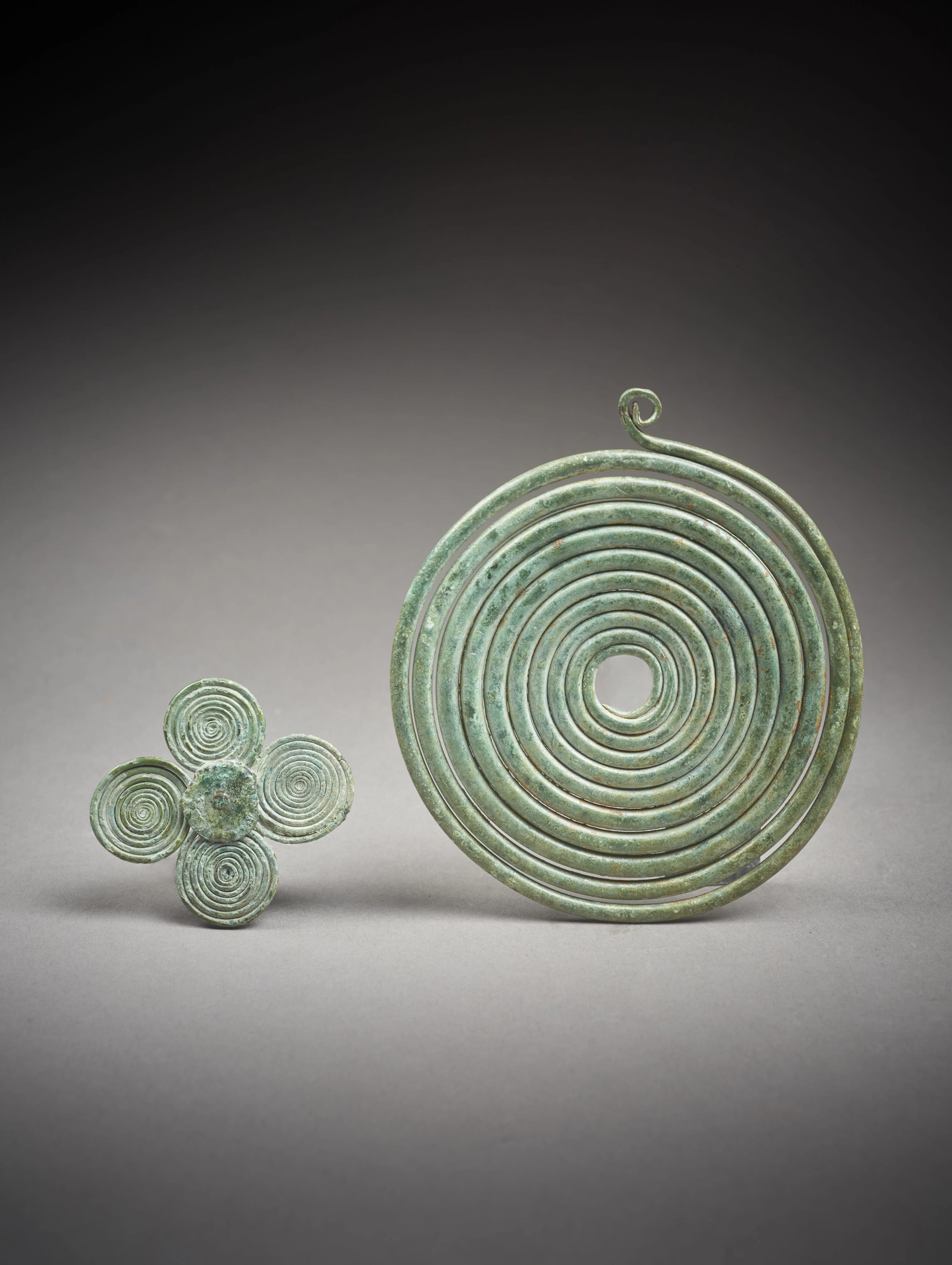 FIBULE ET ORNEMENT À SPIRALES EN BRONZE Art étrusque, VIIIe siècle av. J.-C.