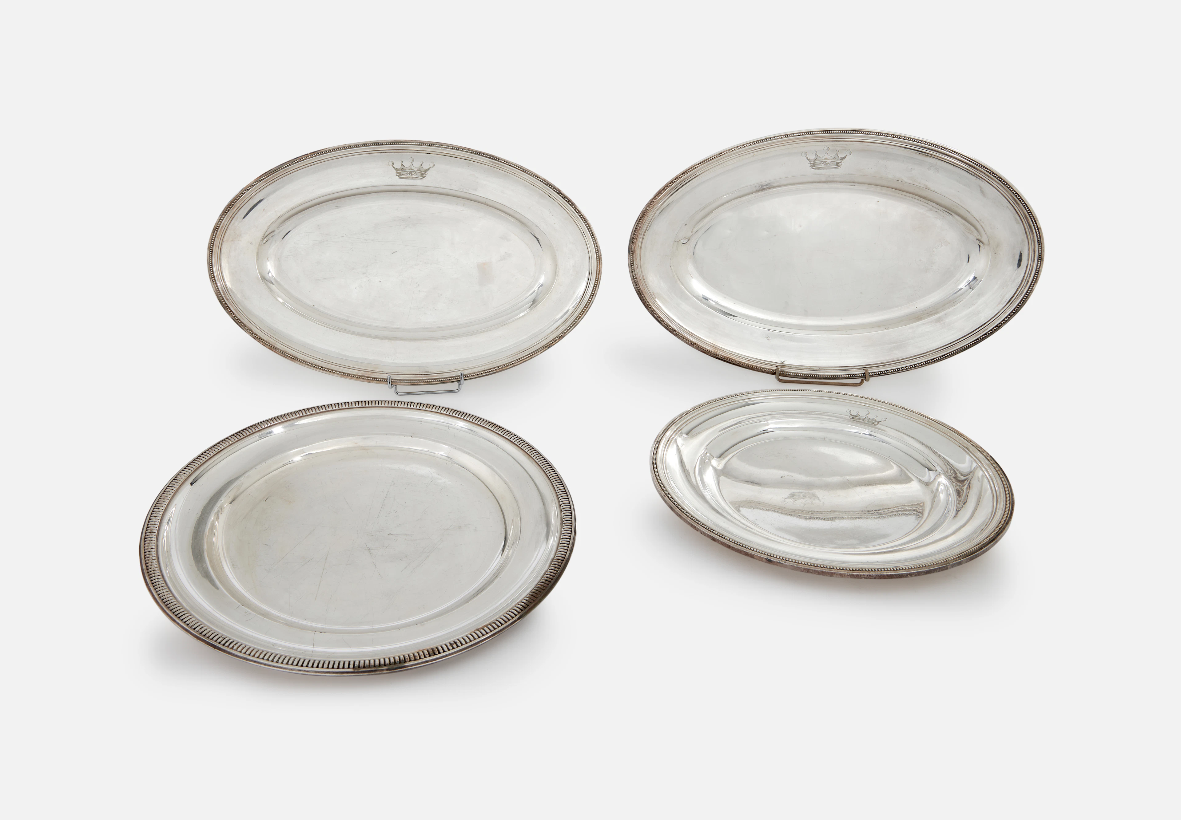 PAIRE DE PLATS OVALES ET UN PLAT ROND EN MÉTAL ARGENTÉ
