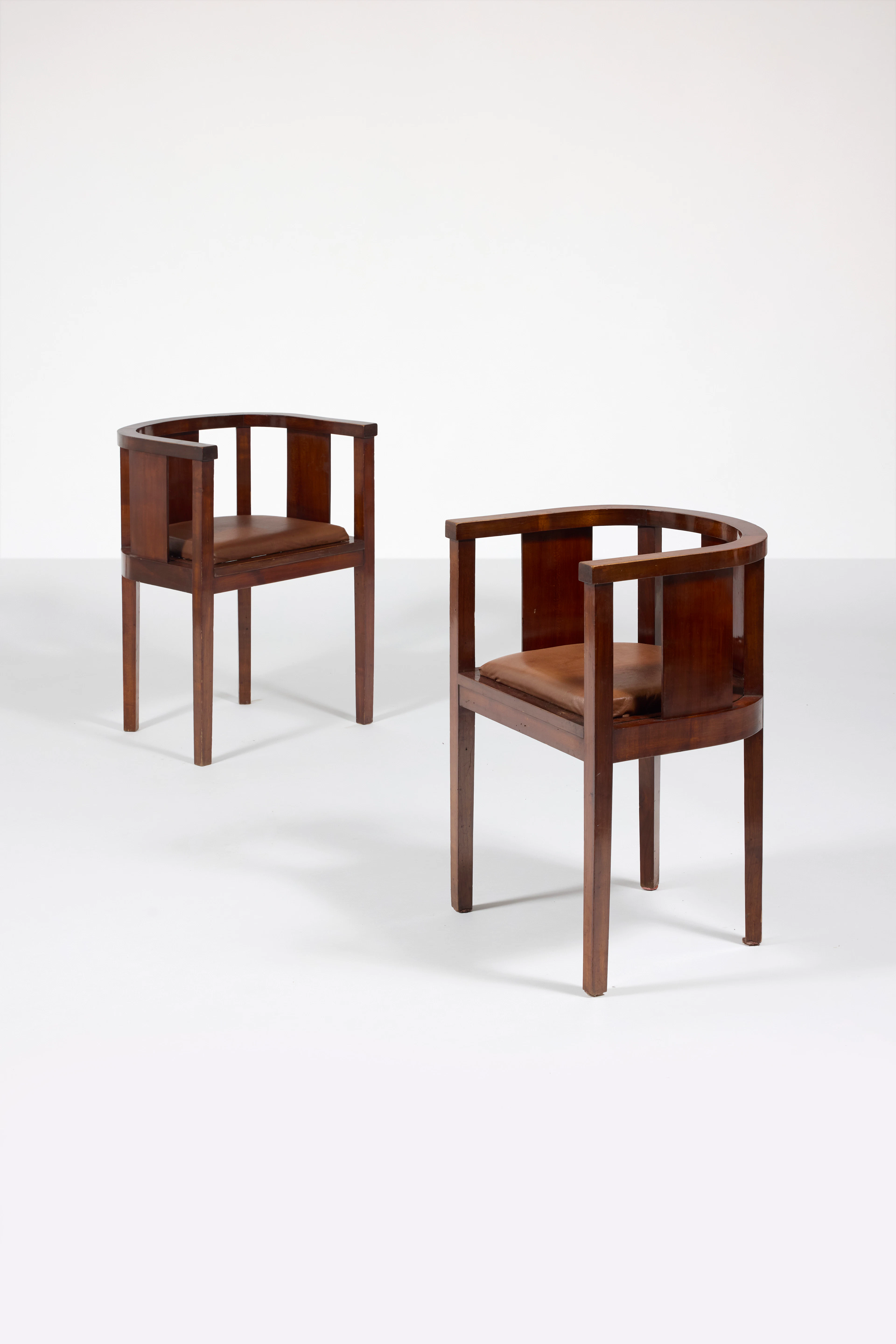 A pair of mahogany and leather armchairs by Francis...