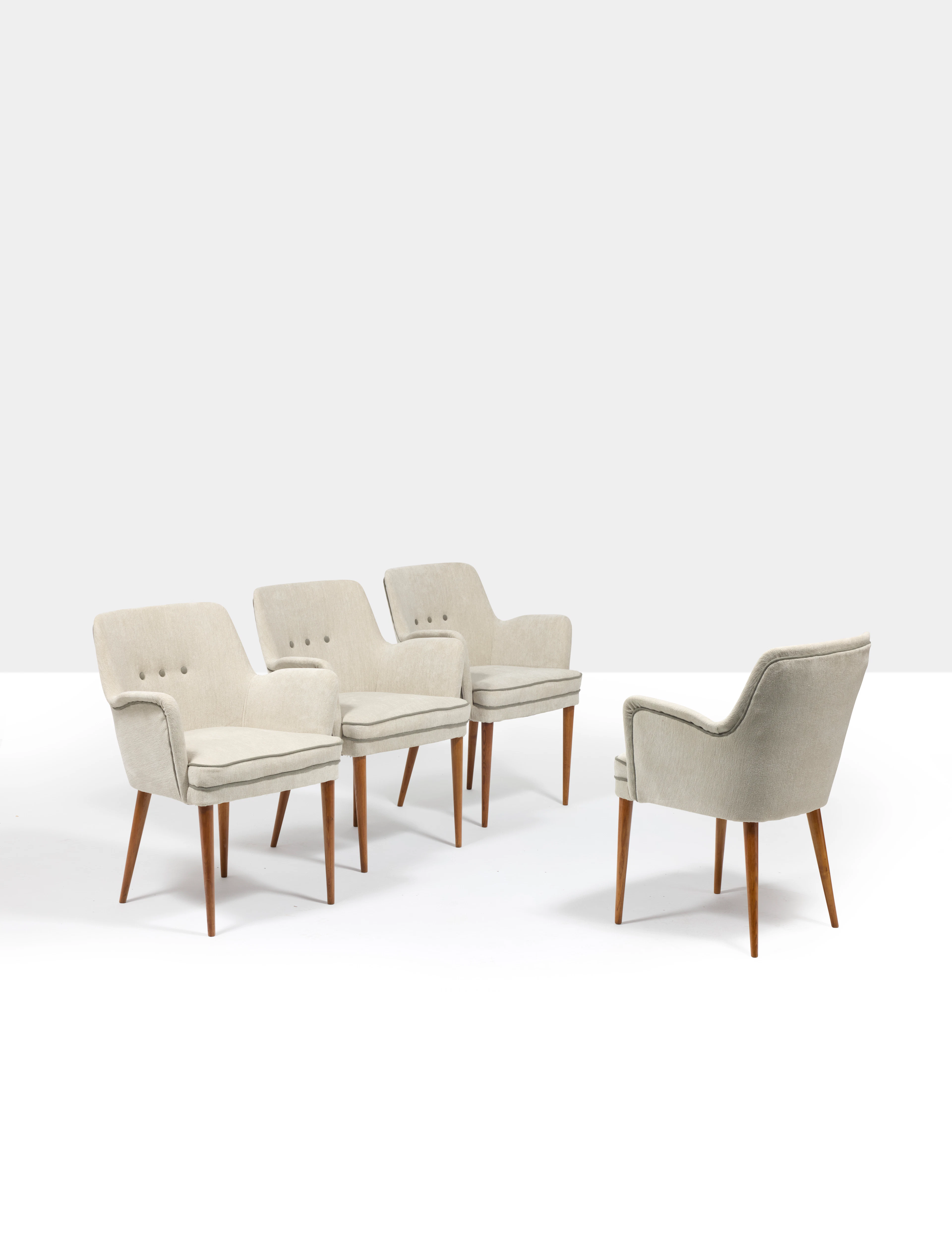 A set of four walnut and velvet armchairs by Osvaldo...