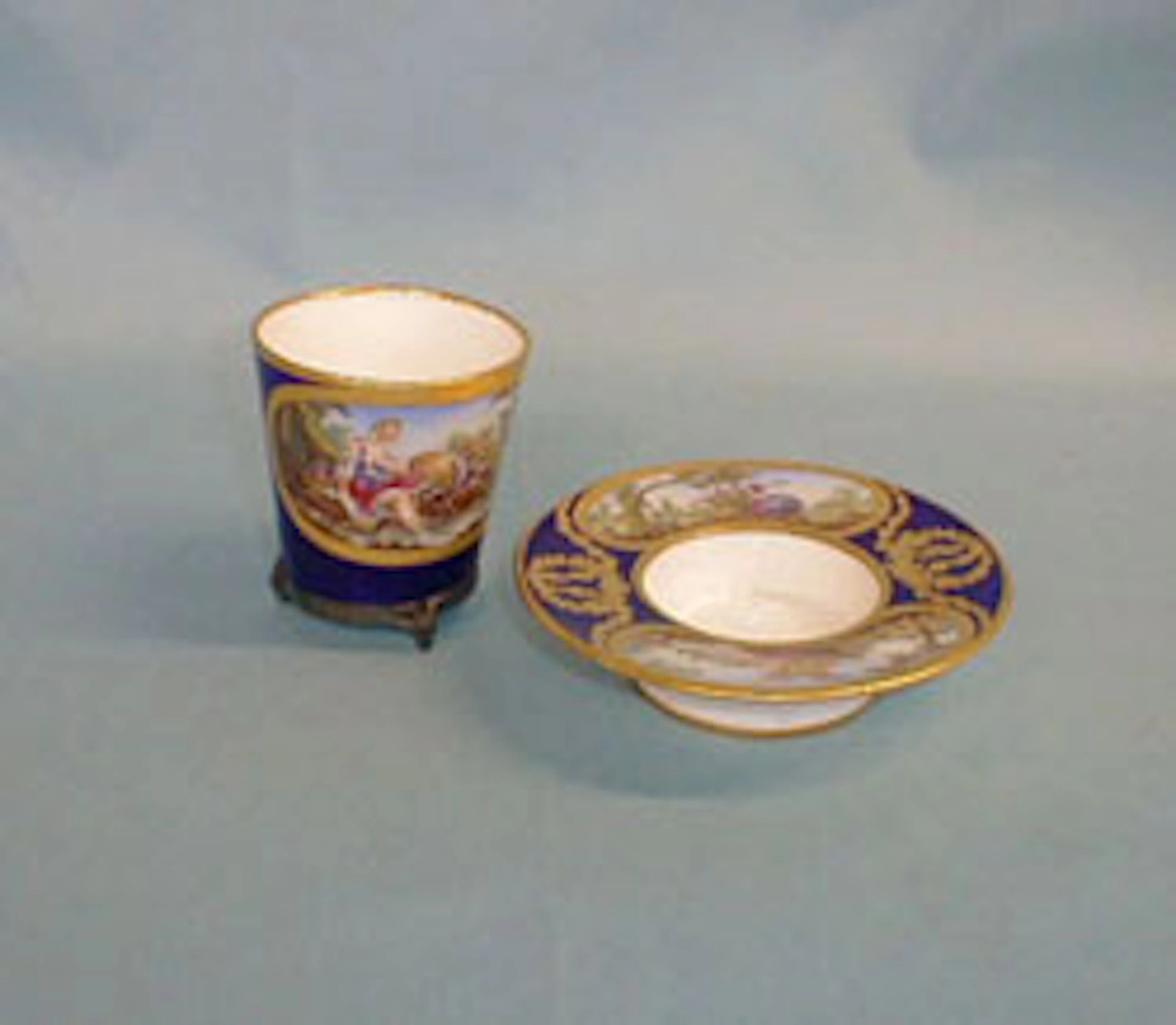 A SEVRES PORCELAIN TREMBLEUSE CUP AND SAUCER, The porcelain 18th c., painted in the 19th c.