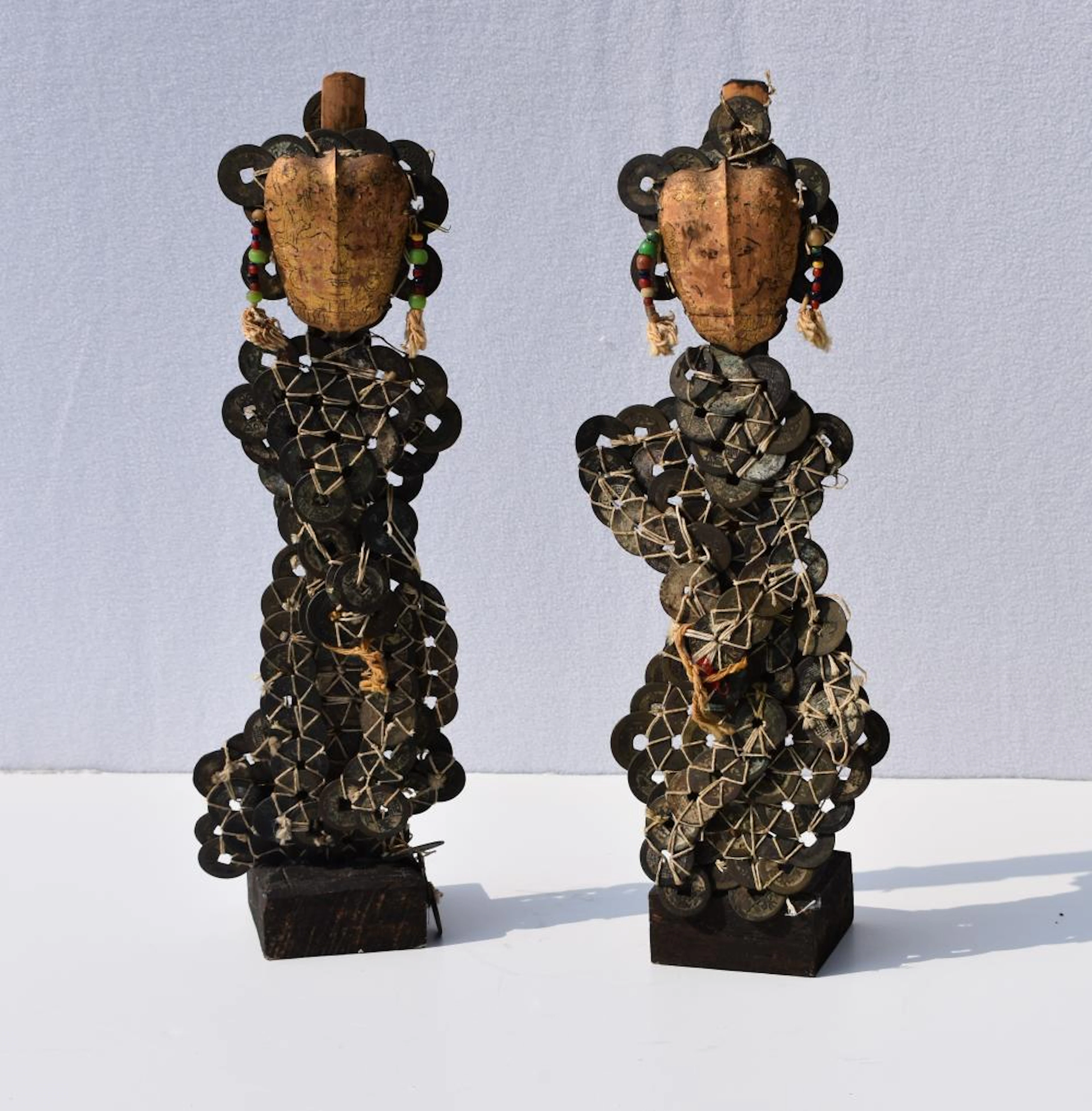 Pair of Balinese coin figurines Coins and gilt metal faces