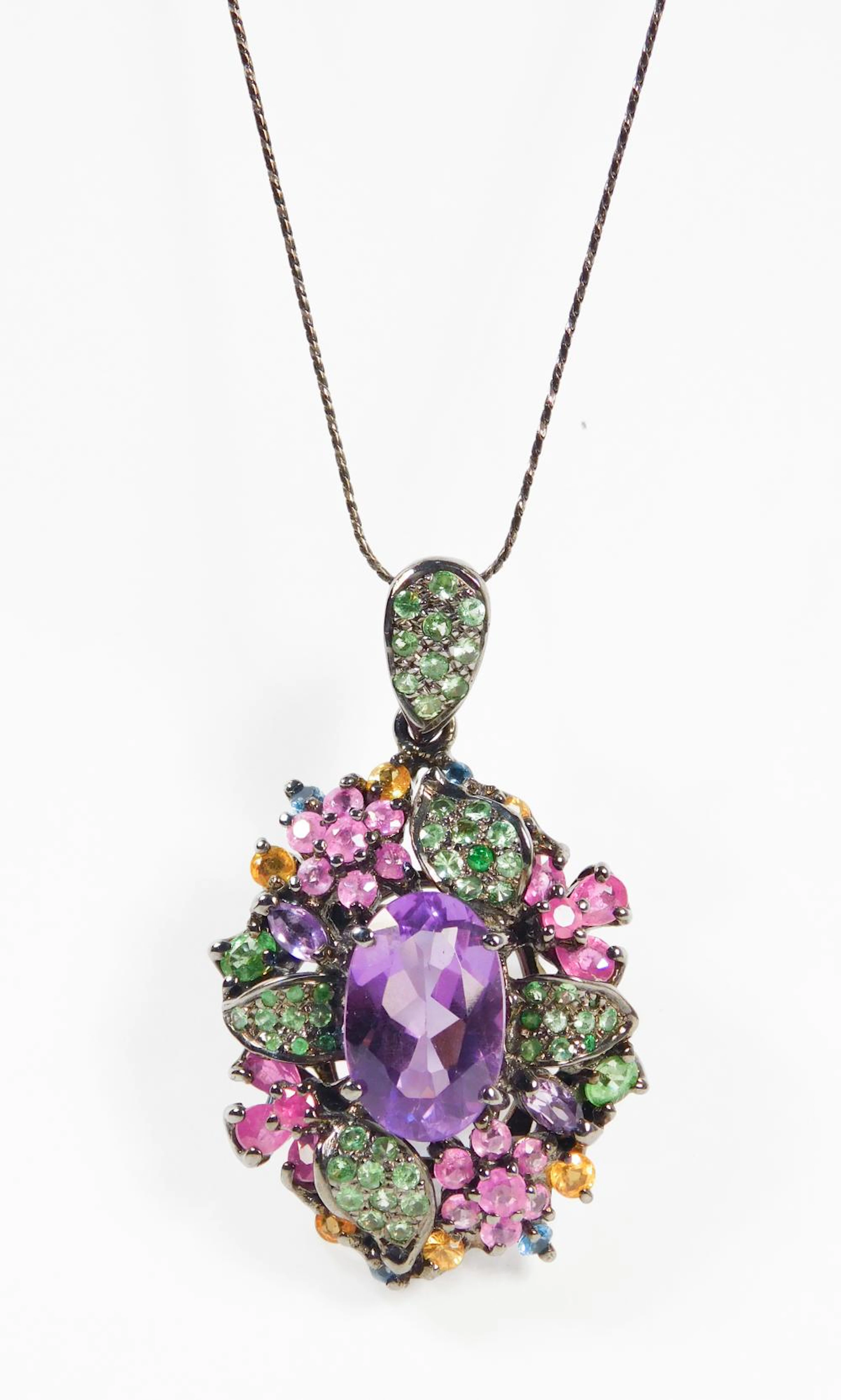 BROCHE COLGANTE CON CADENA en plata rodiada con amatistas, rubíes y peridotos.