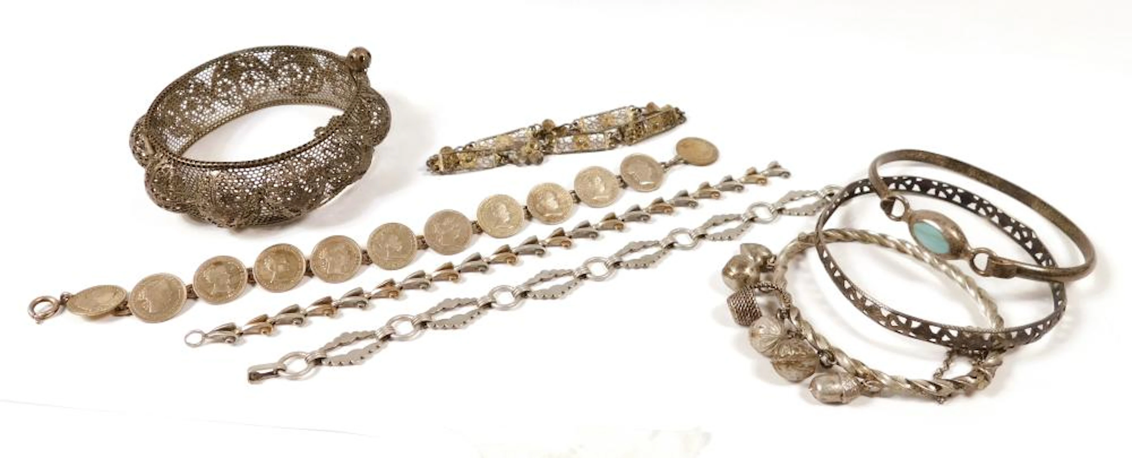 COLECCIÓN DE DISTINTAS PULSERAS ANTIGUAS en plata Una ancha de metal calado.