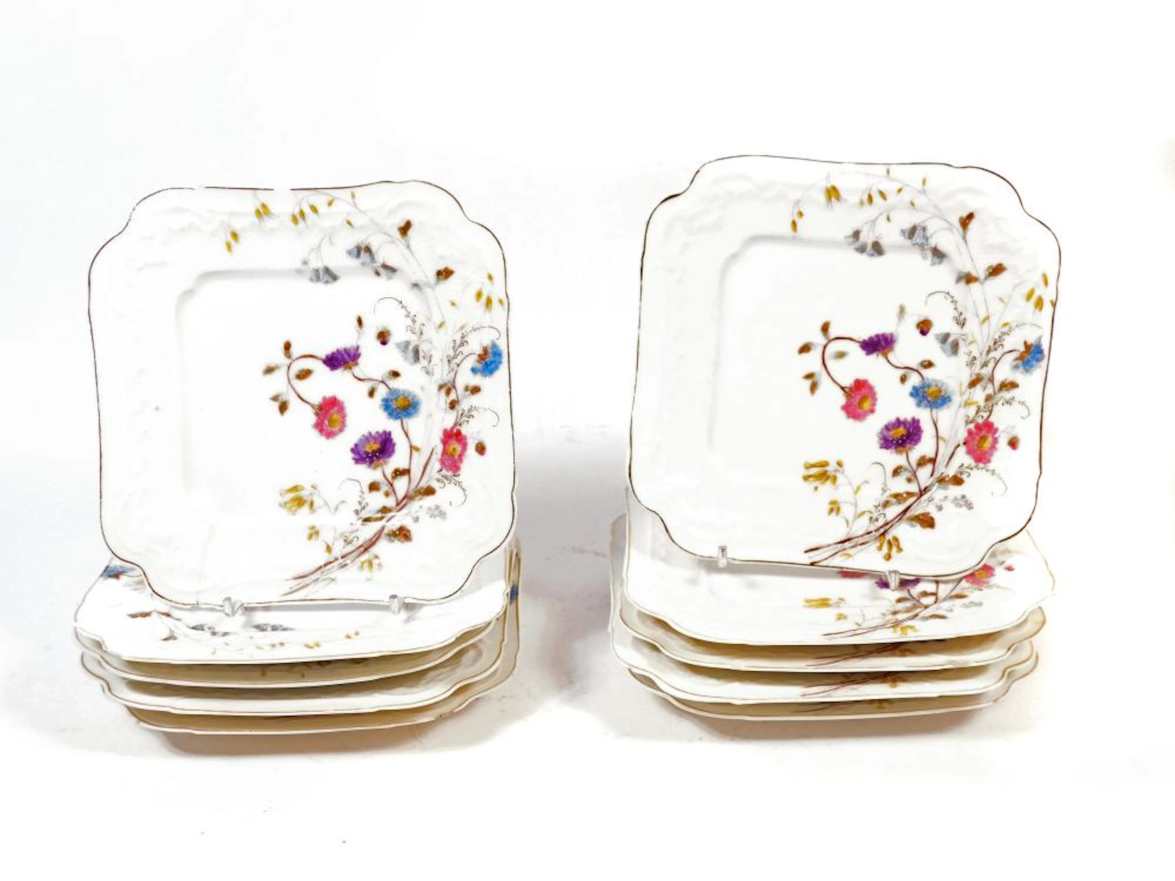 COLECCIÓN DE 10 PLATOS en fina porcelana con detalles de...
