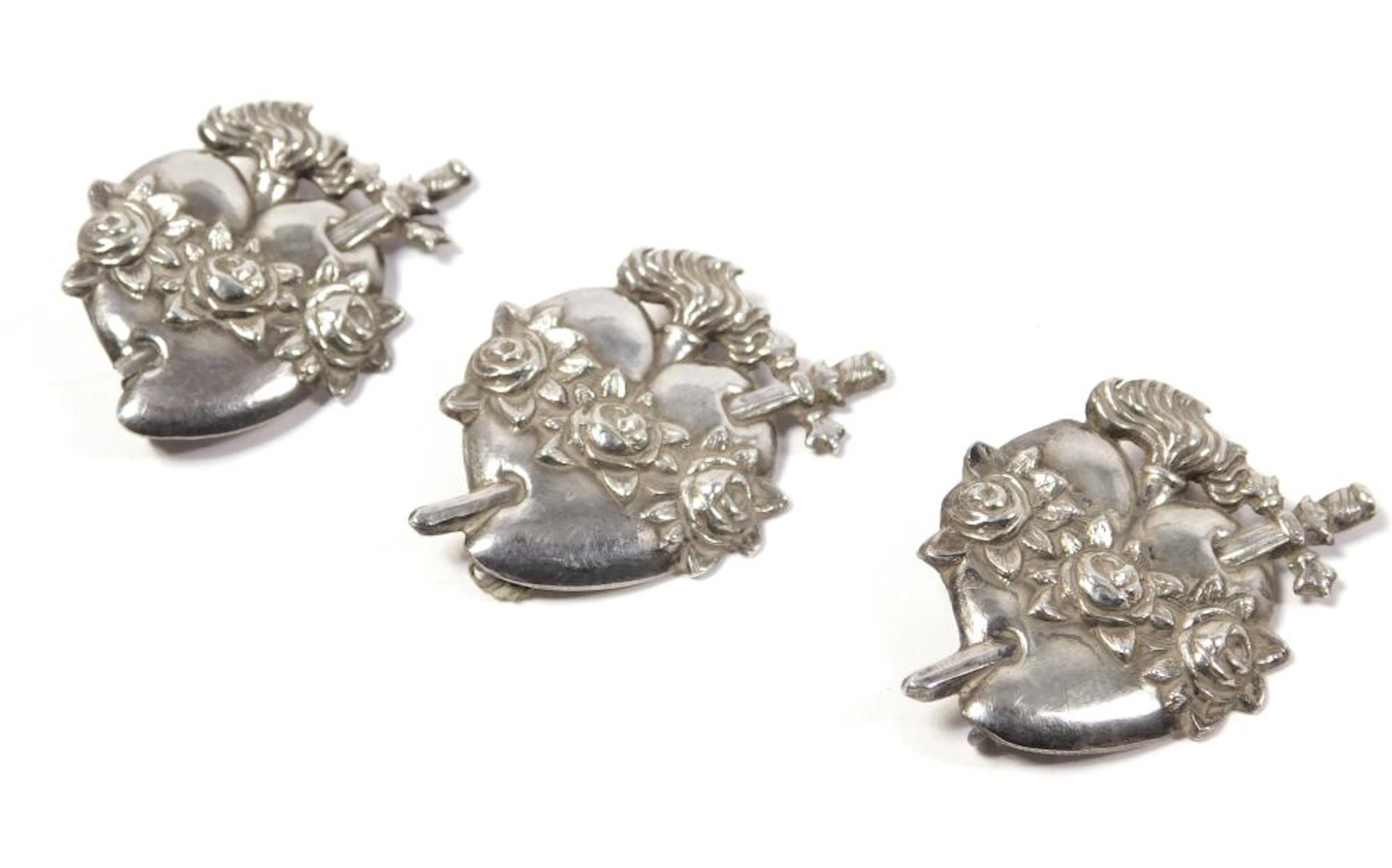 TRES BROCHES DEL SAGRADO CORAZÓN DE MARÍA en plata repujada Largo: 3.2 cm.