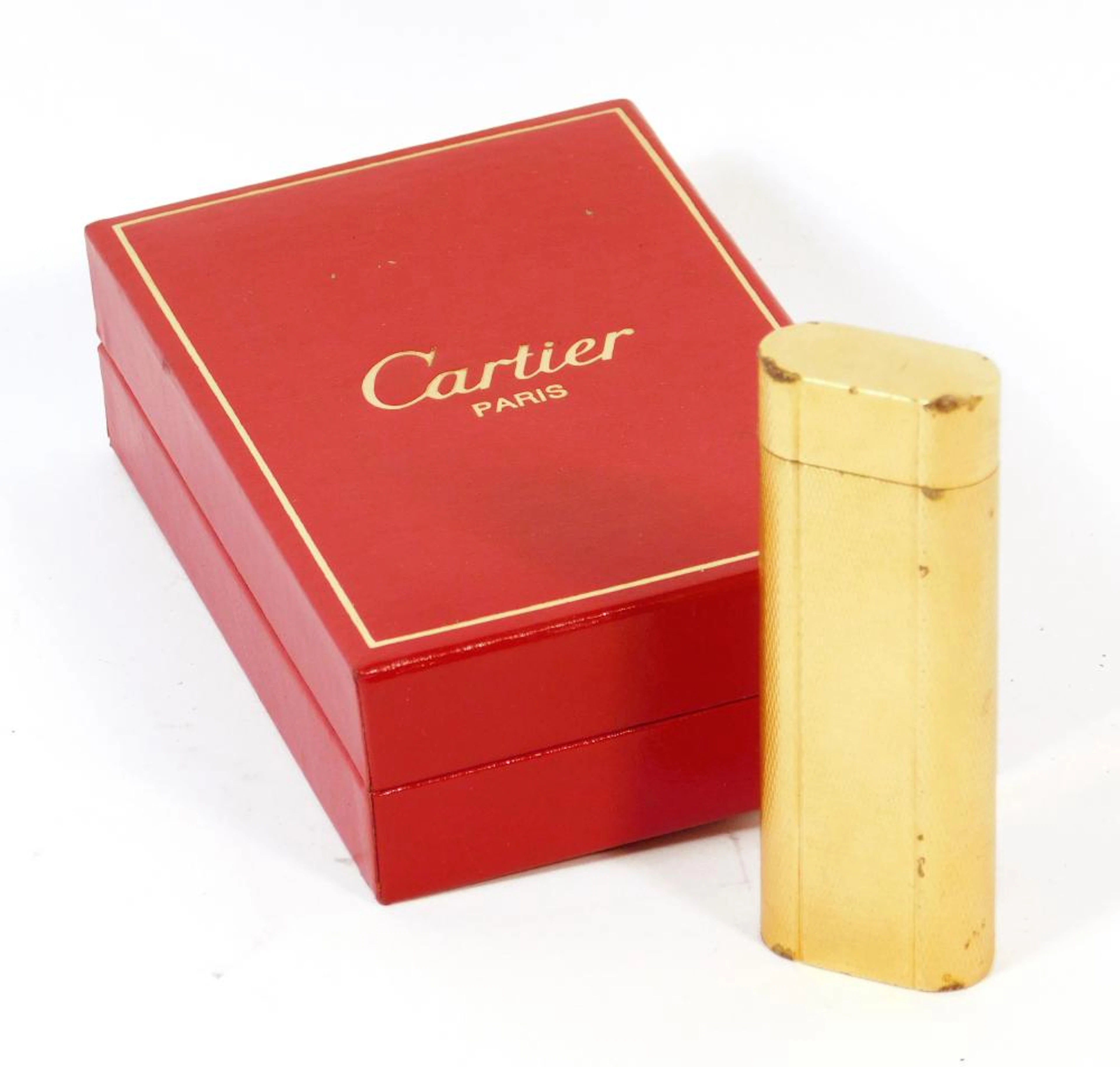 CARTIER. ENCENDEDOR en plaqué de oro amarillo guilloxé. Con estuche original.