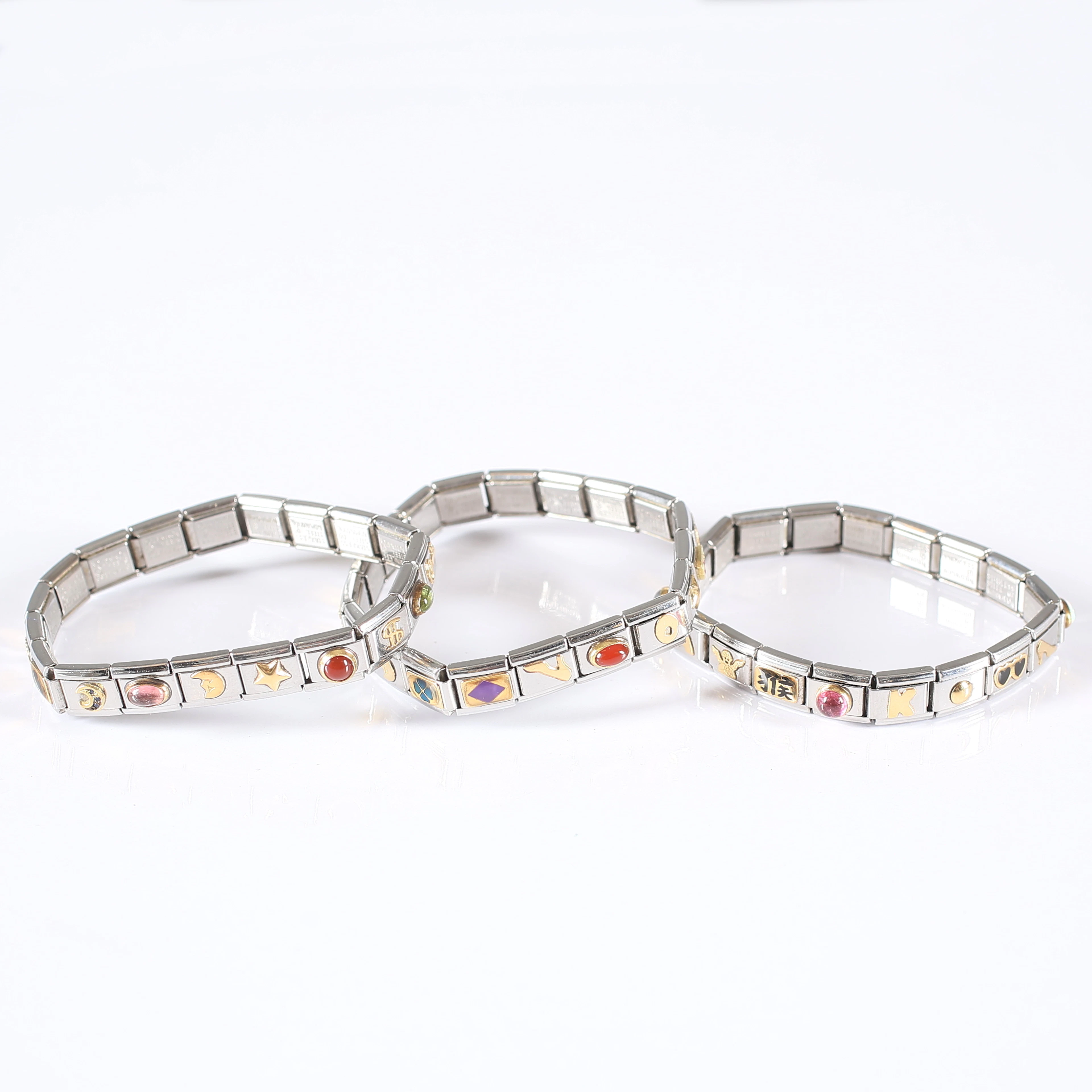 ARMBAND, 3 st, "Nomination", rostfritt stål samt 18K guld-detaljer.
