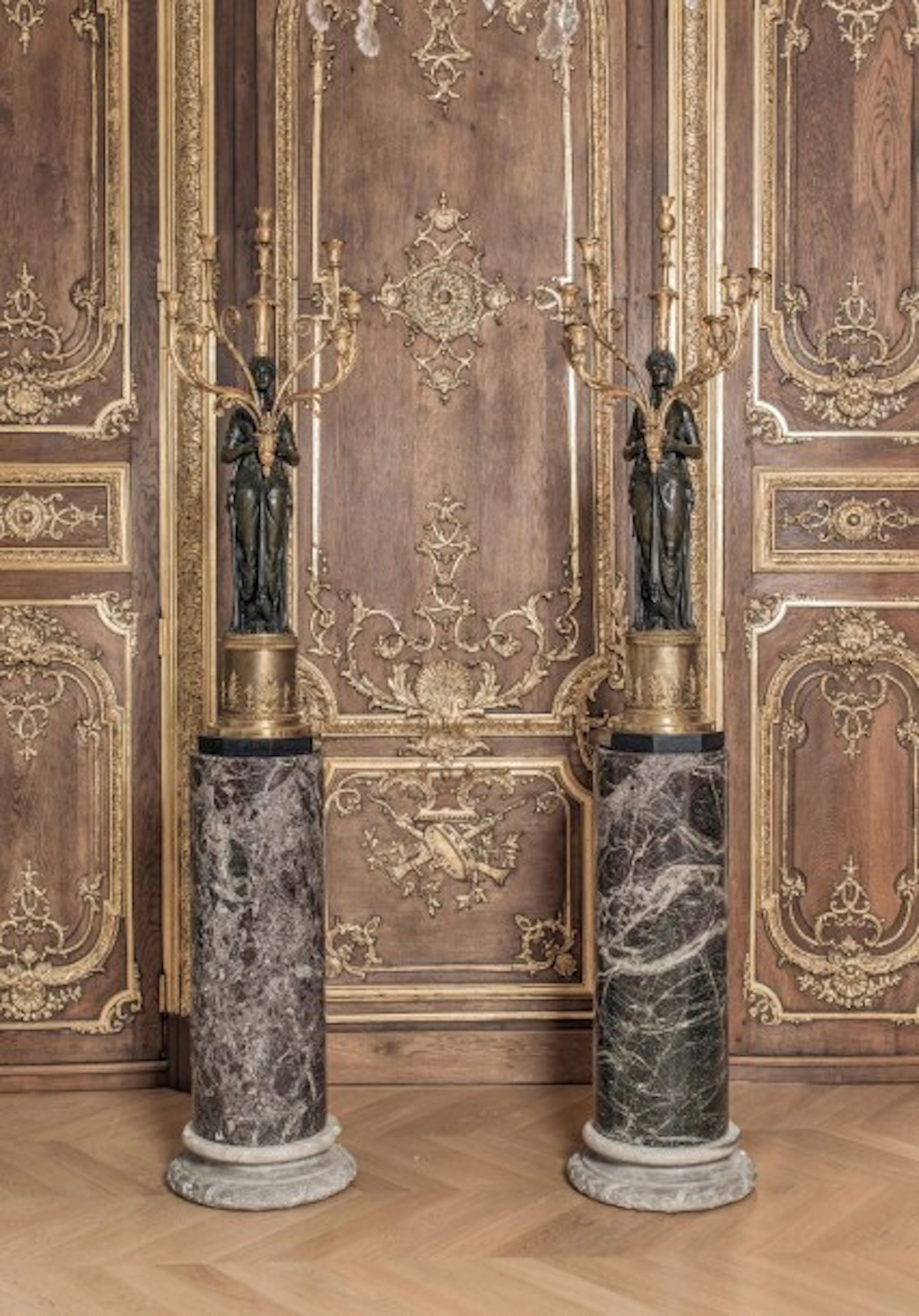 *Paire d'importants candélabres en bronze à patine vert antique et bronze doré