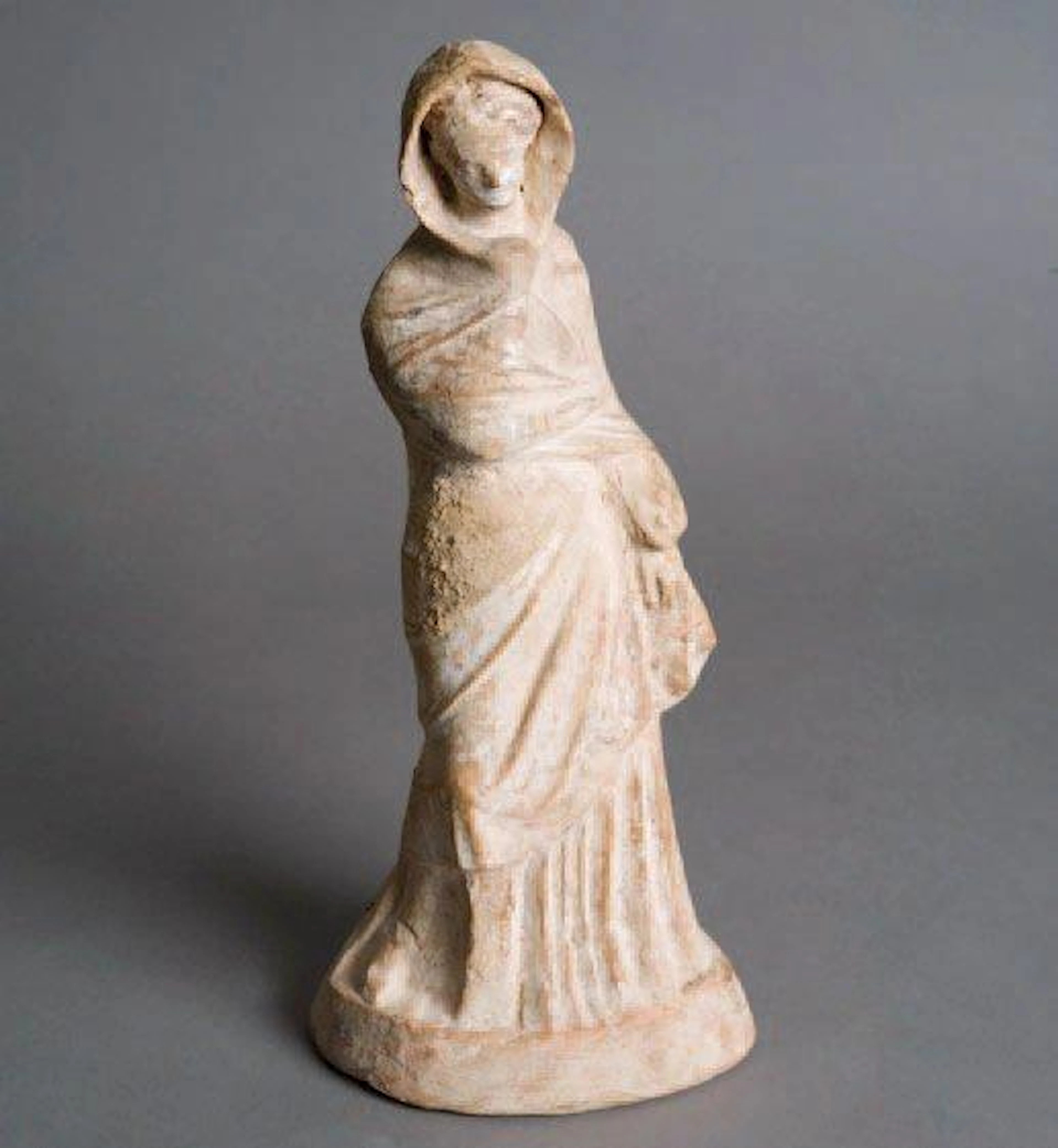 Statuette de Tanagra debout sur une base vêtue d'un chiton a...