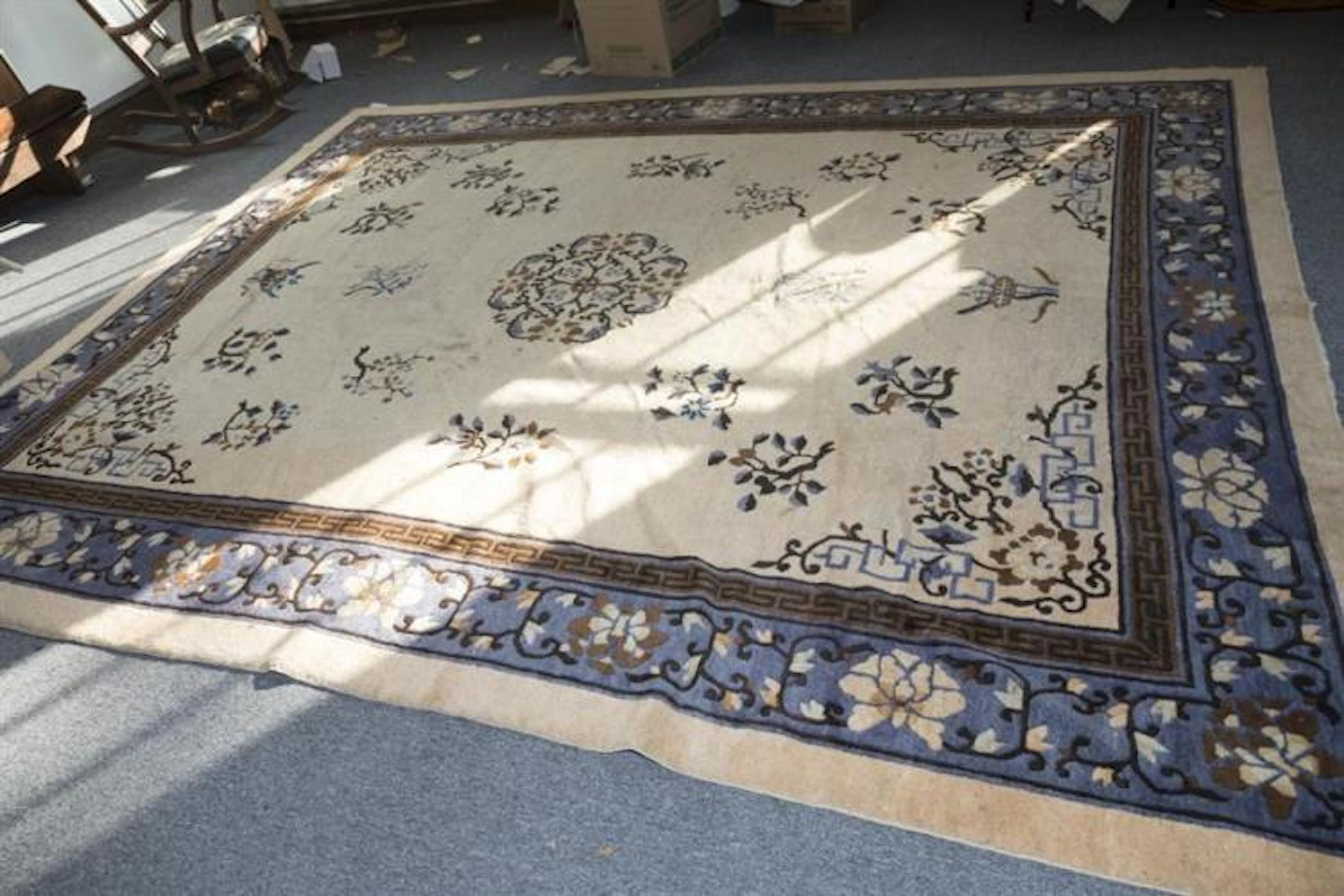 Handwoven Chinese room rug, central medallion on ivory field within a greek key guard border, and blue primary border.