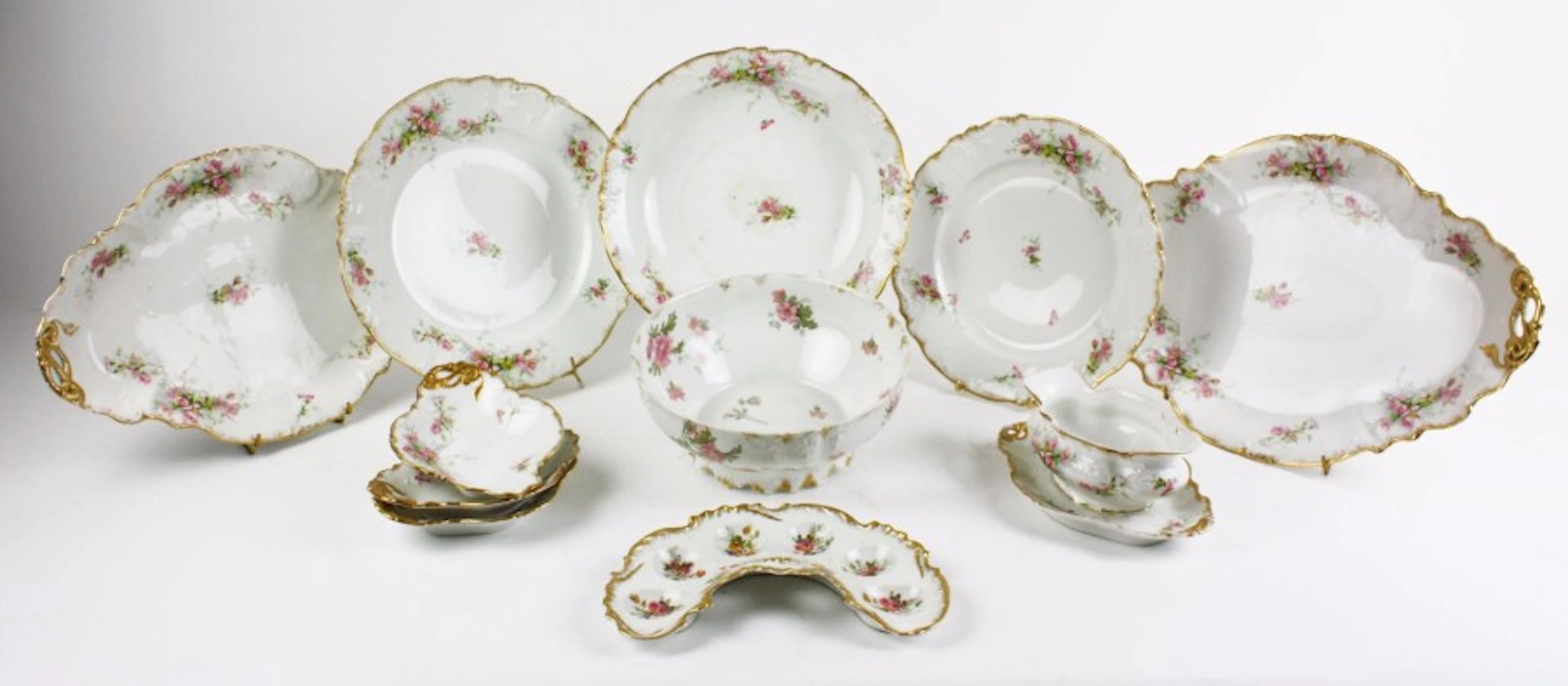 LIMOGES Service de table en porcelaine blanche à décor de fleurs...