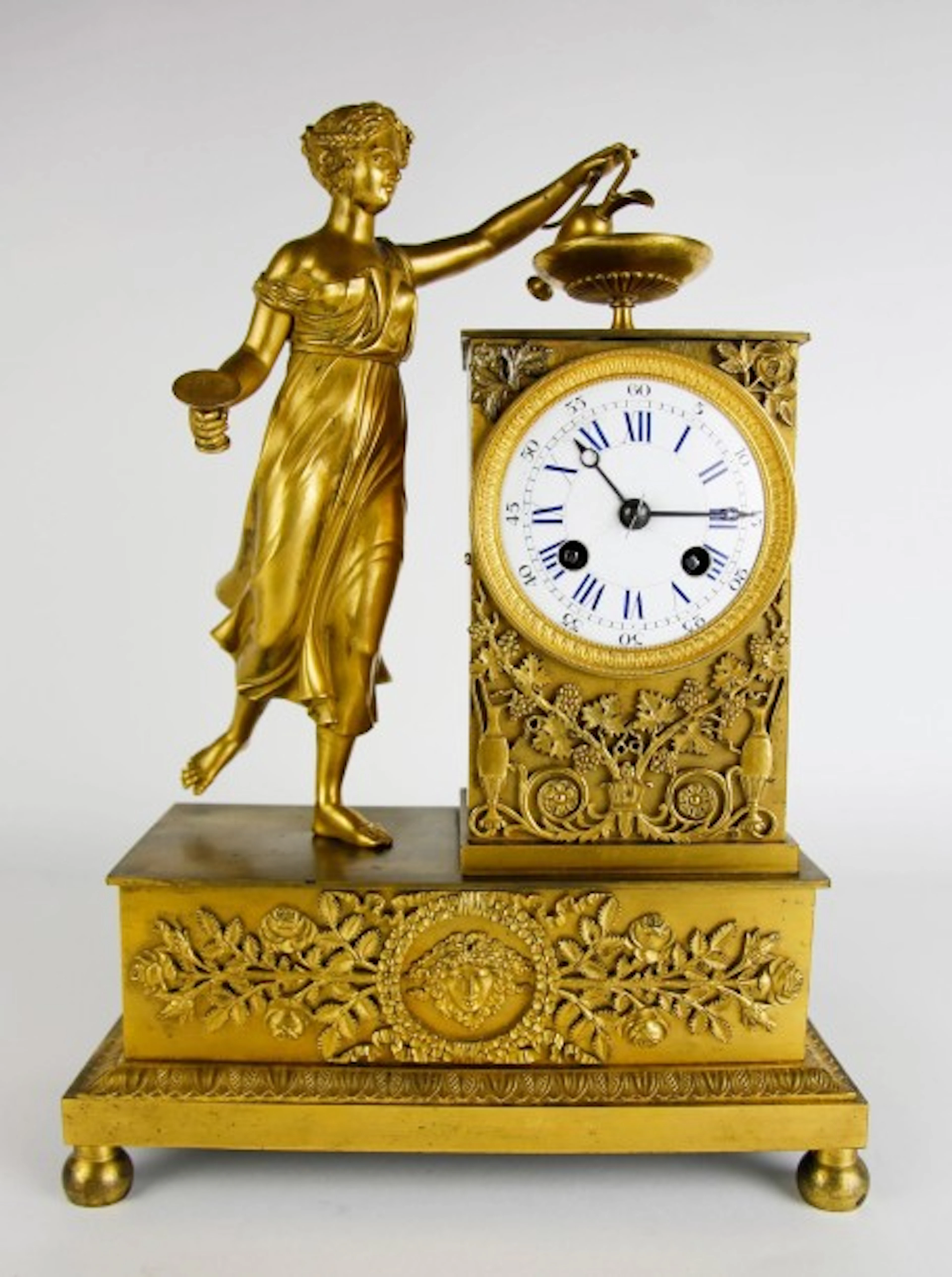 PENDULE en bronze doré et ciselé à décor d'une femme à la cruche