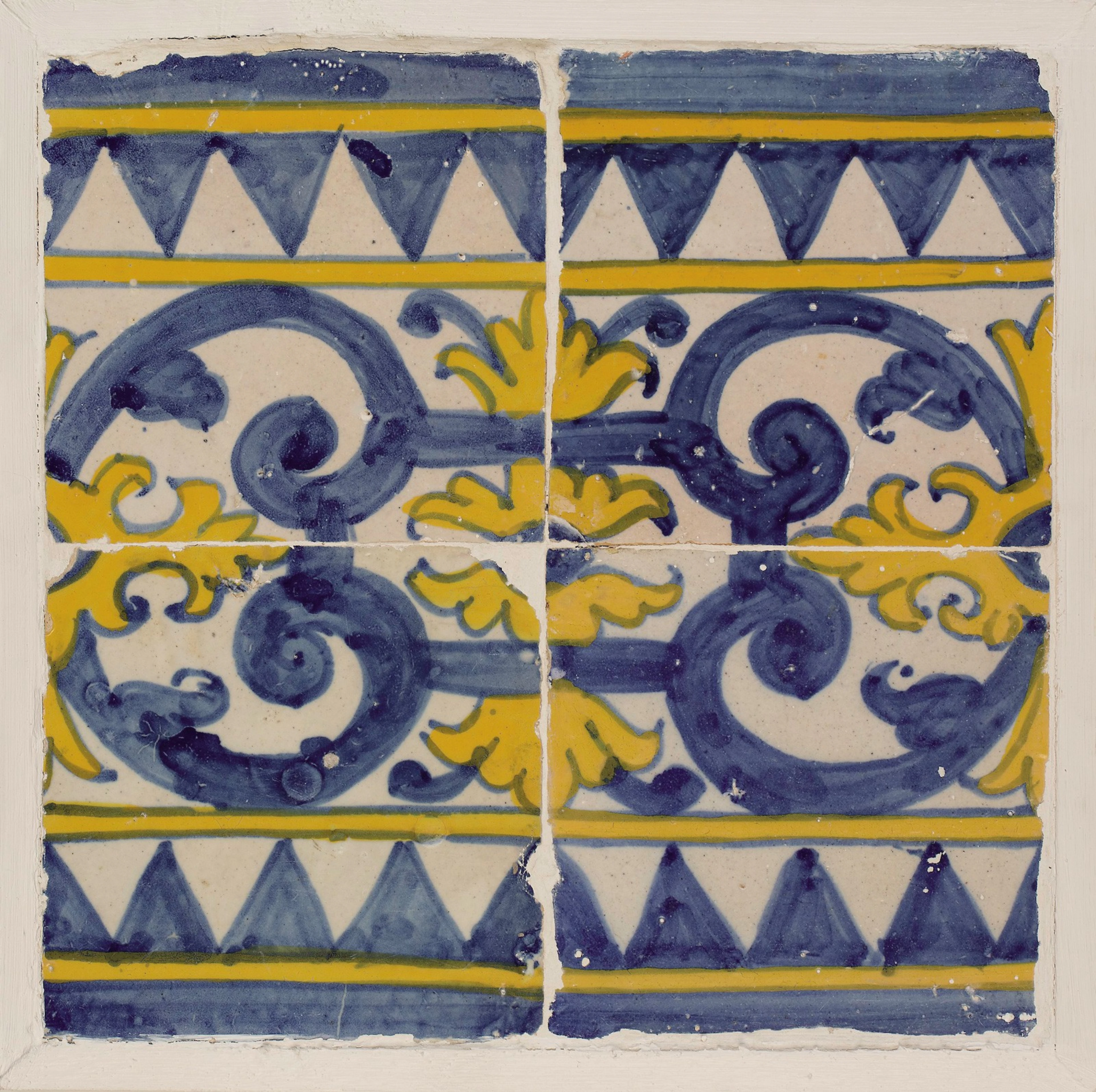 Conjunto de cuatro azulejos de cerámica esmaltada en azul de cobalto y amarillo