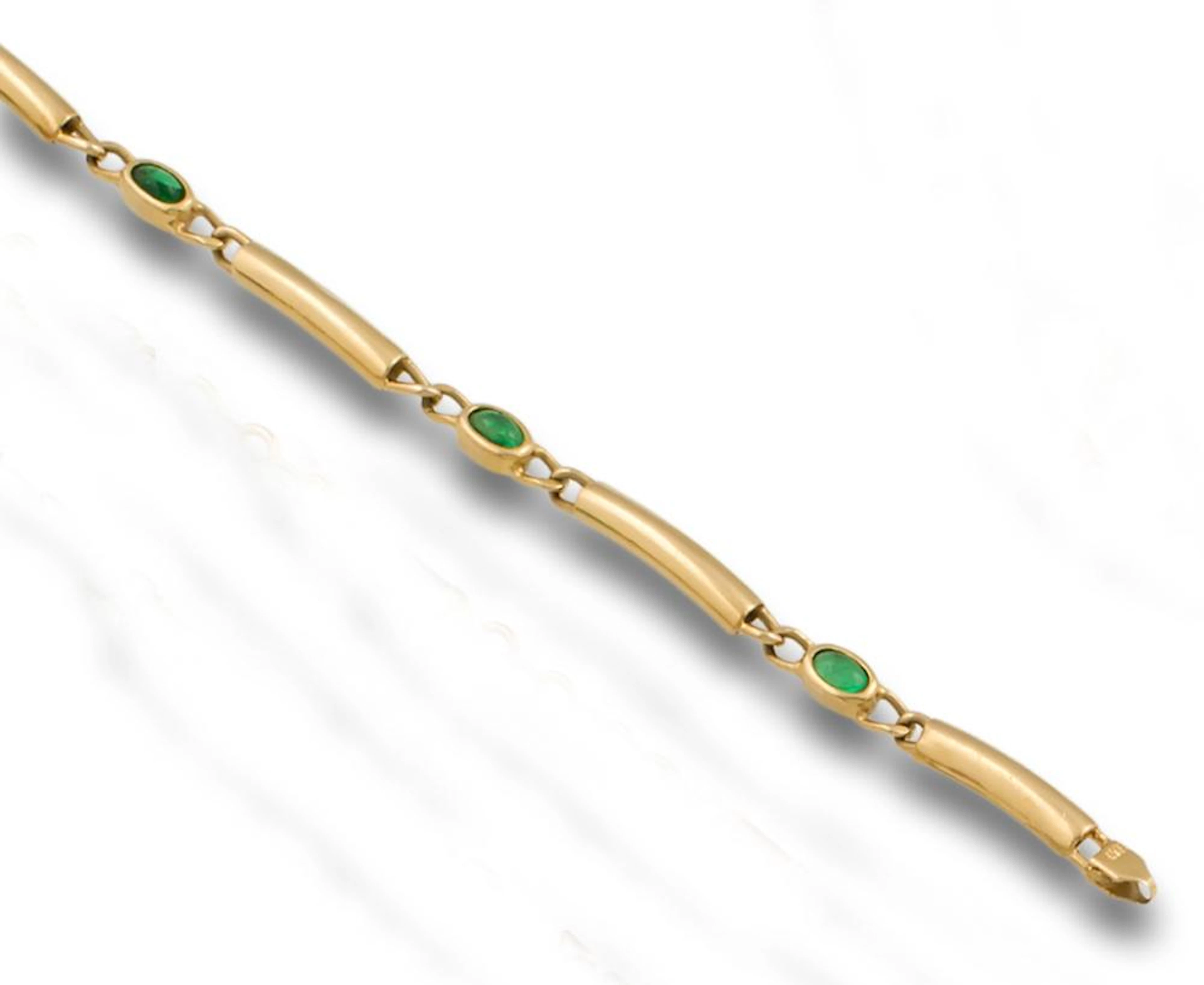 AN EMERALD AND GOLD BRACELET