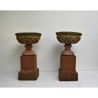 A pair of buff terracotta garden urns on associated pedestal bases