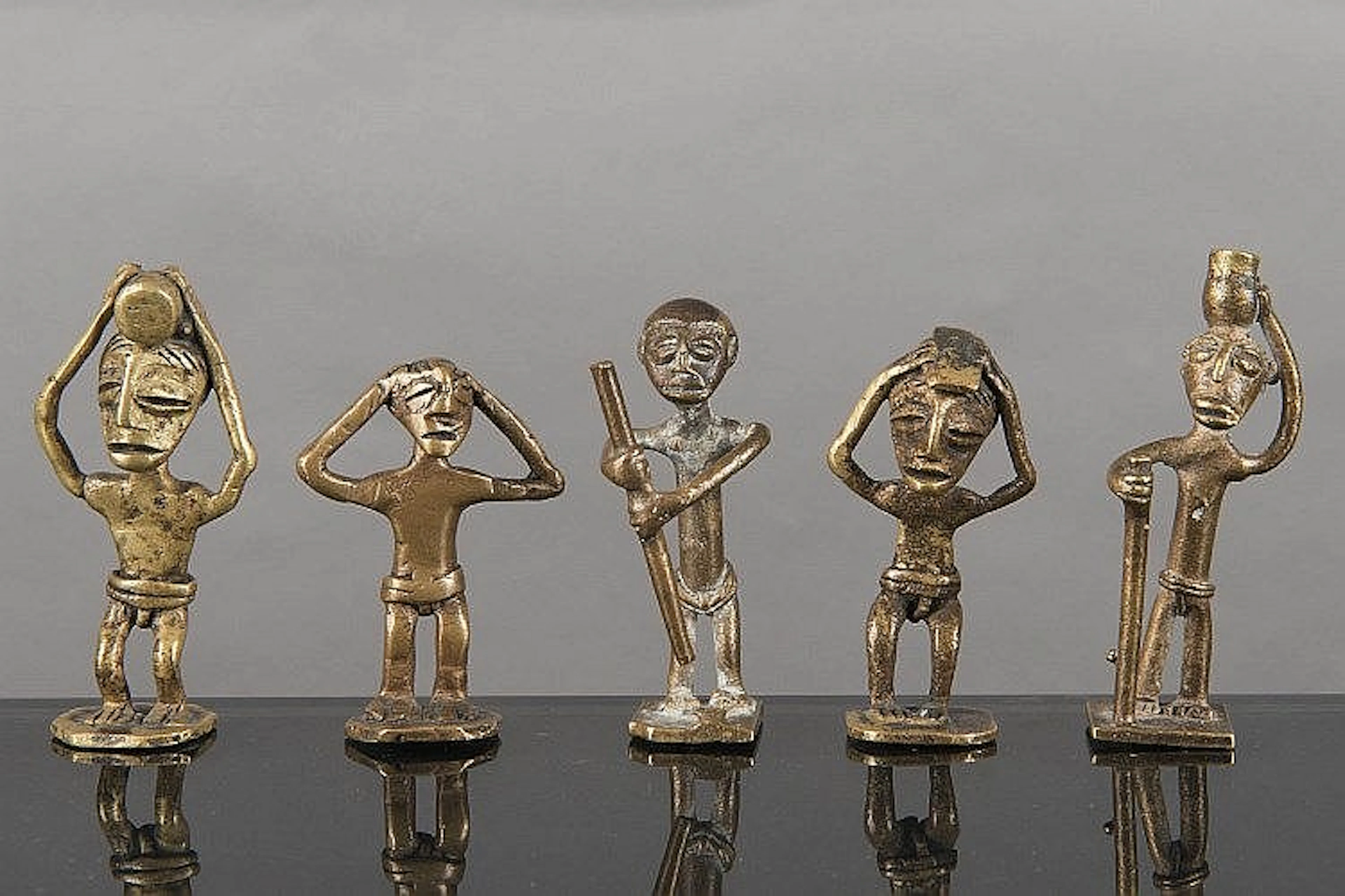 5 poids Ashanti en bronze à patine jaune de forme humaine.