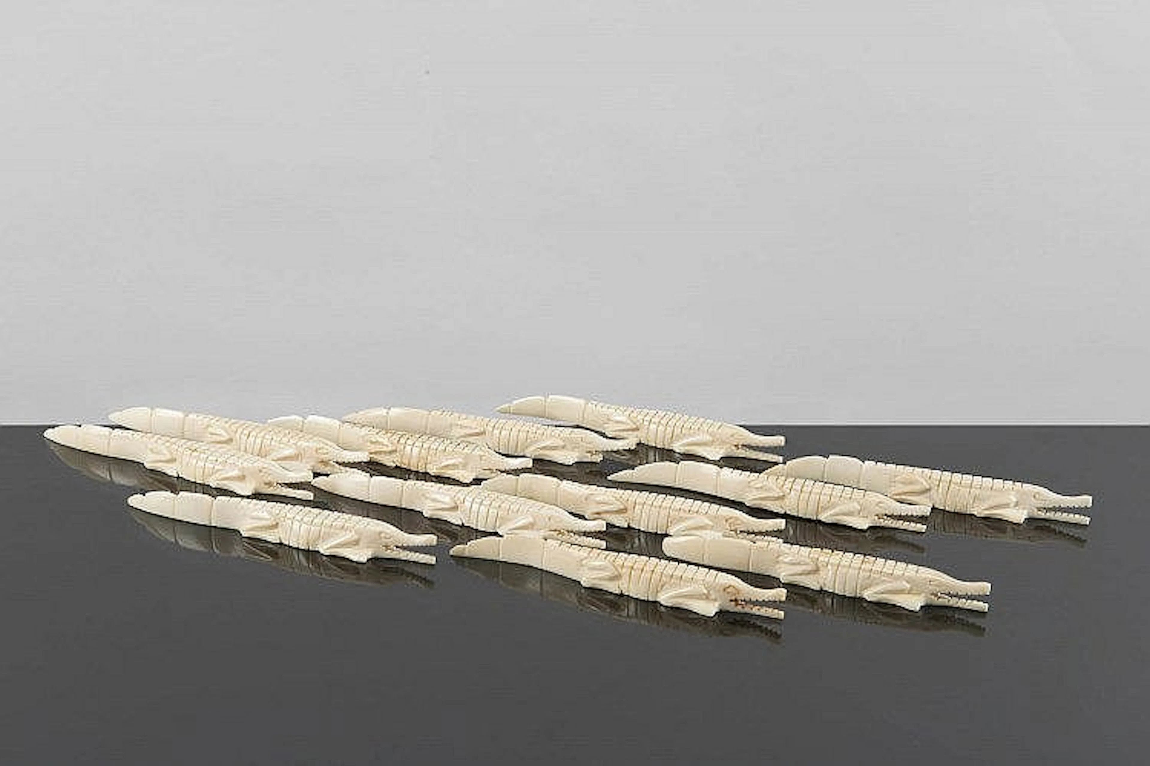 12 porte-couteaux en ivoire en forme de crocodile.