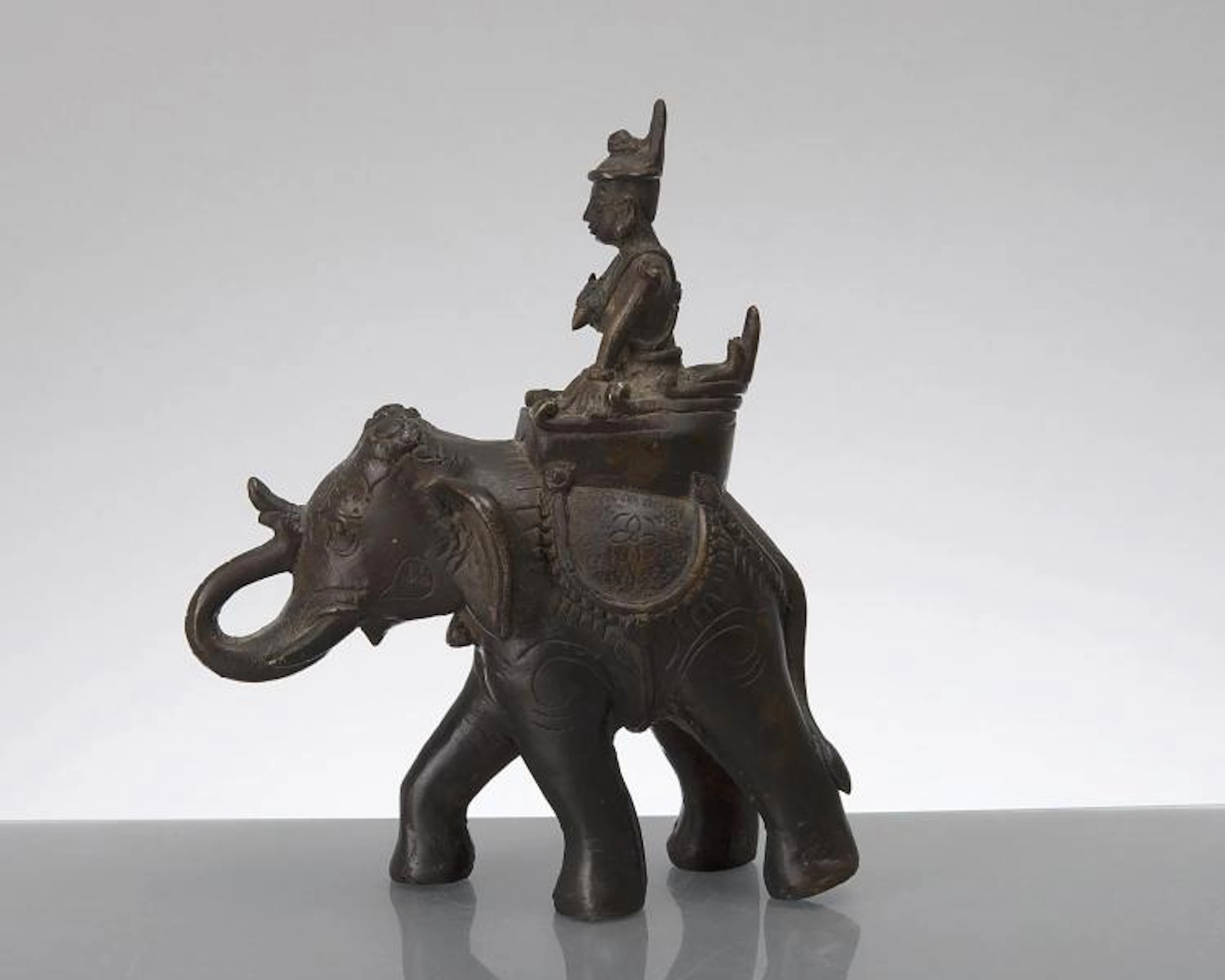 sculpture d'un éléphant en bronze à patine brune surmonté d'un cornac, Inde XXe.